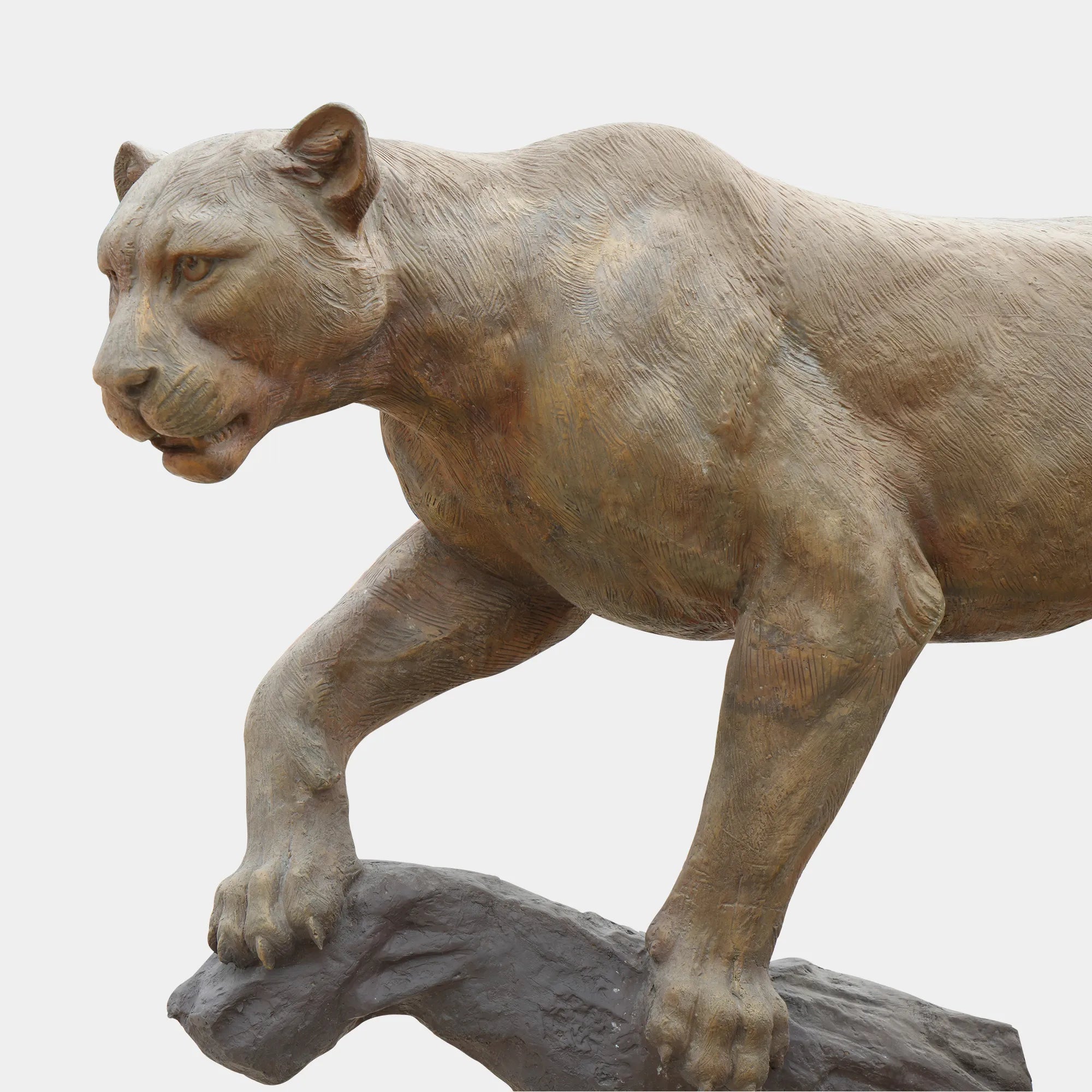 Full view of bronze panther sculpture standing on a tree branch showing lifelike pose.