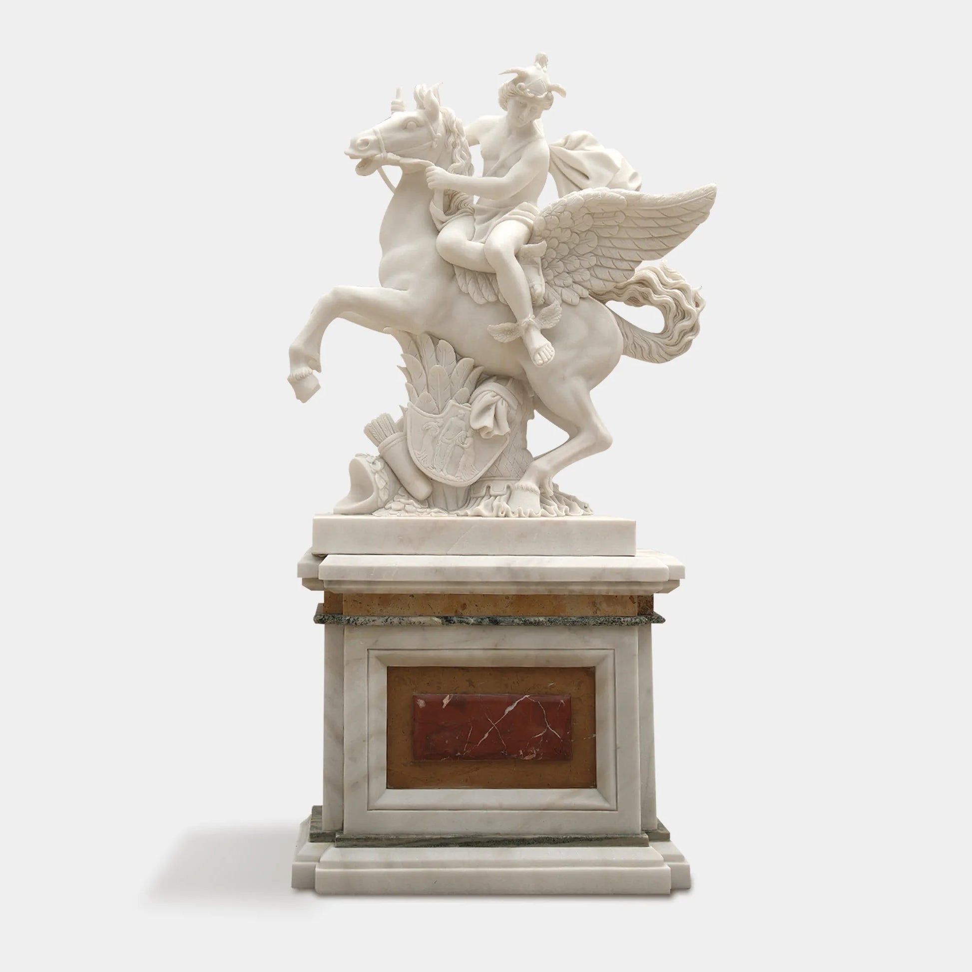 White marble sculpture of a winged horse with an angel above.
