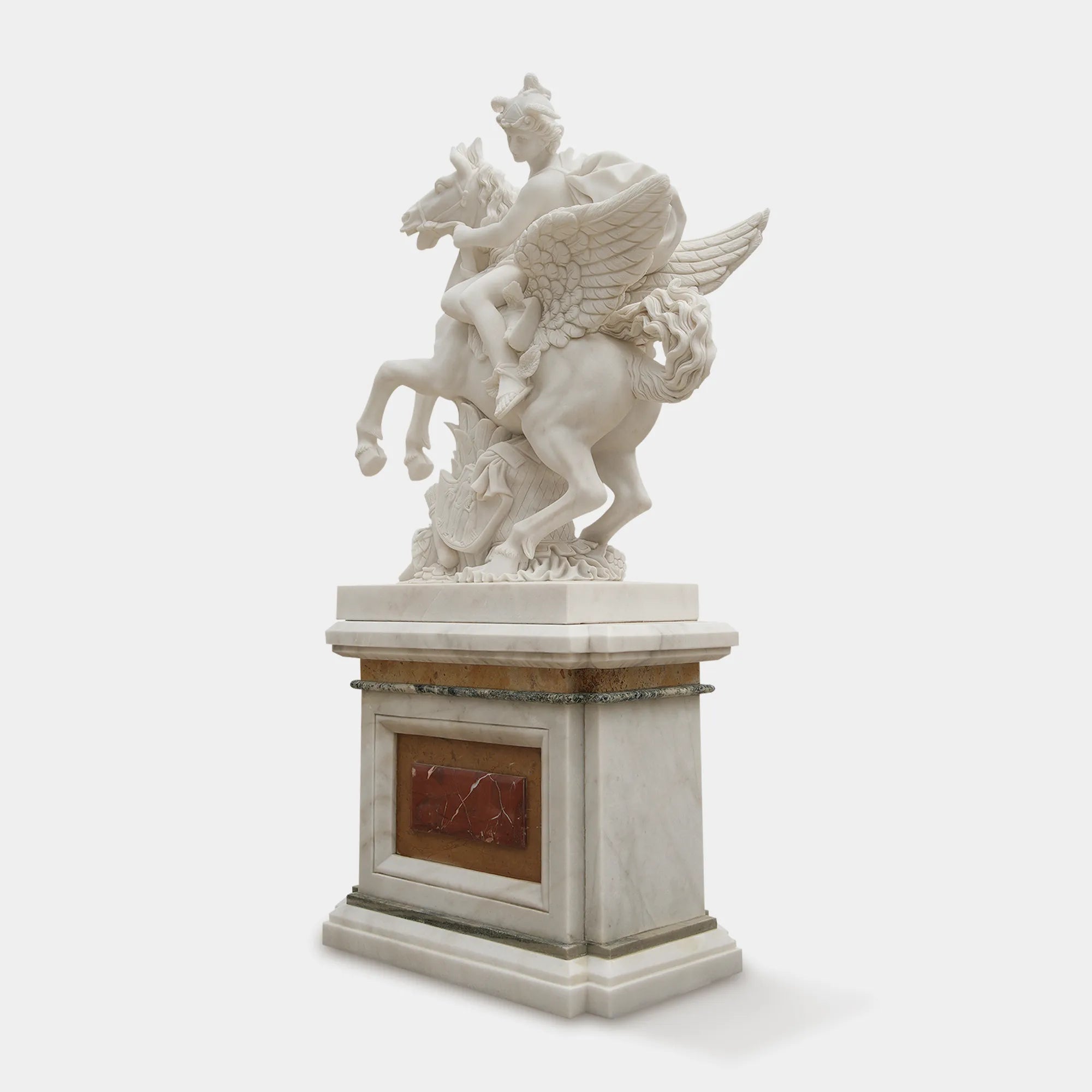 White marble sculpture of a winged horse with an angel above.