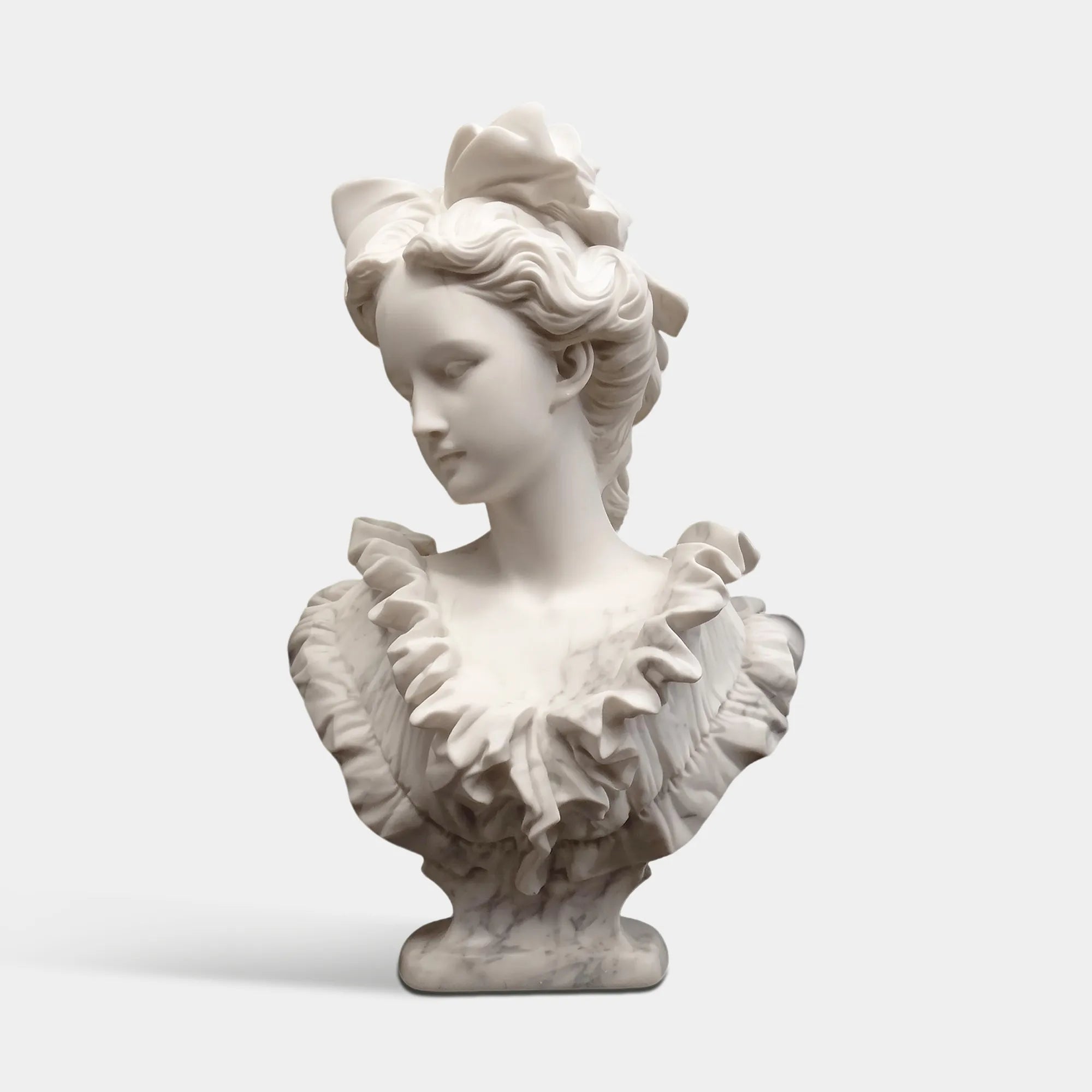Marble classical bust sculpture of a girl with bow and dress detail for galleries and interiors.