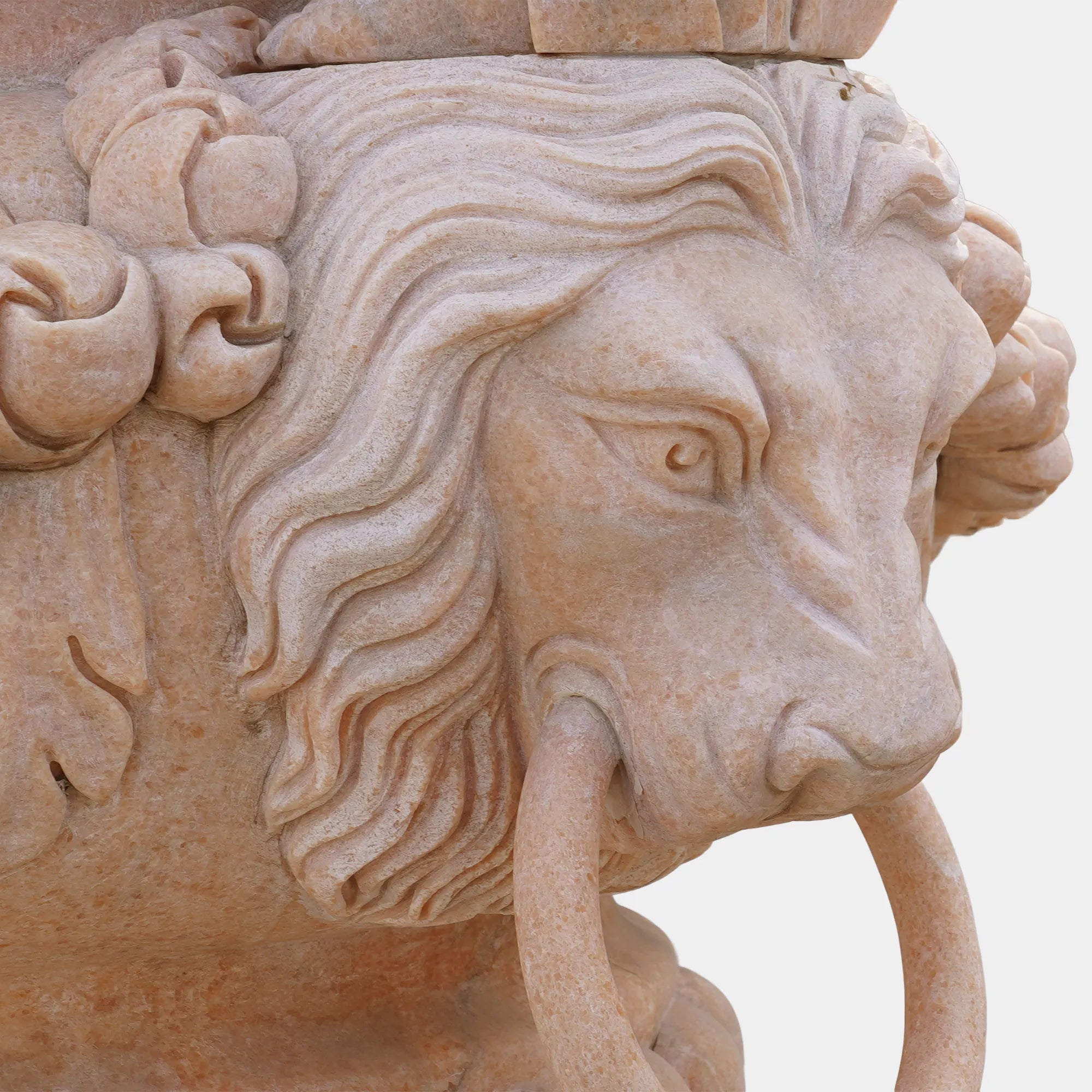 Marble planter sculpture with angel figures, lion head carvings, and floral relief base, displayed at a villa entrance with plants inside.