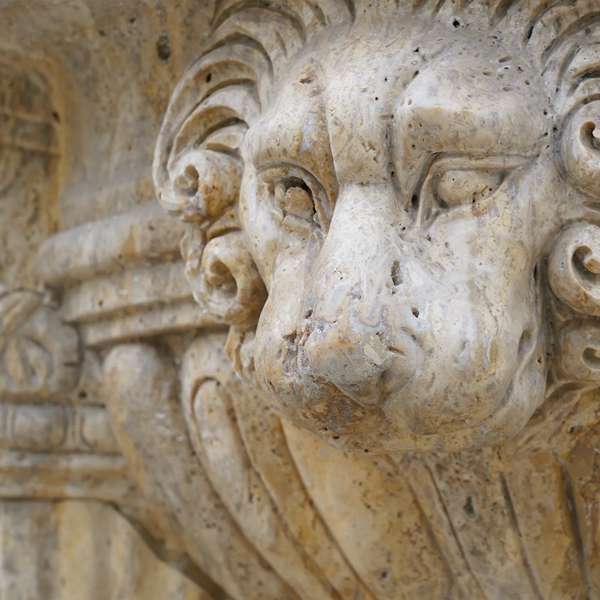 A finely crafted marble jardiniere sculpture with elegant lion heads and classical floral motifs. 