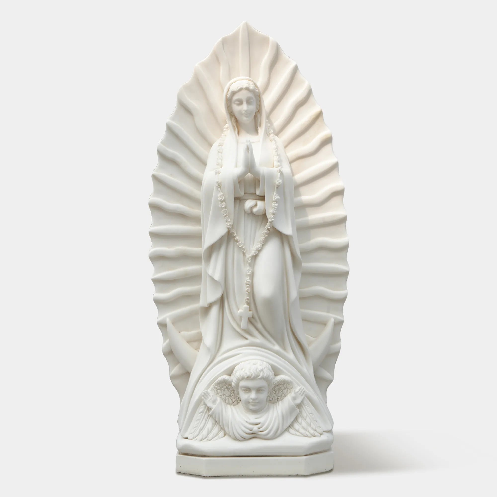 Marble sculpture of the Virgin Mary displayed in a softly lit chapel interior.