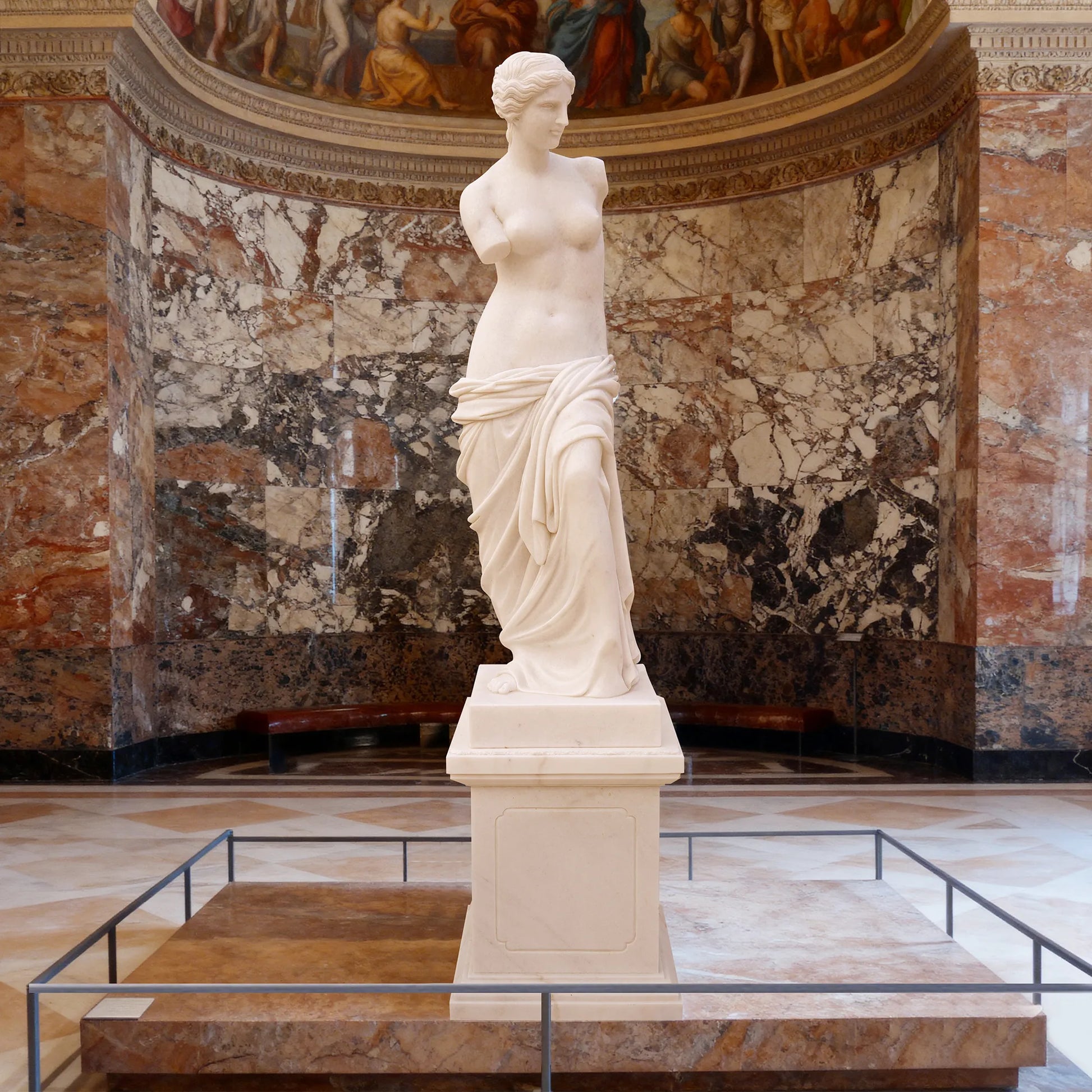 Marble sculpture of Venus de Milo with detailed Greek design standing on a pedestal.