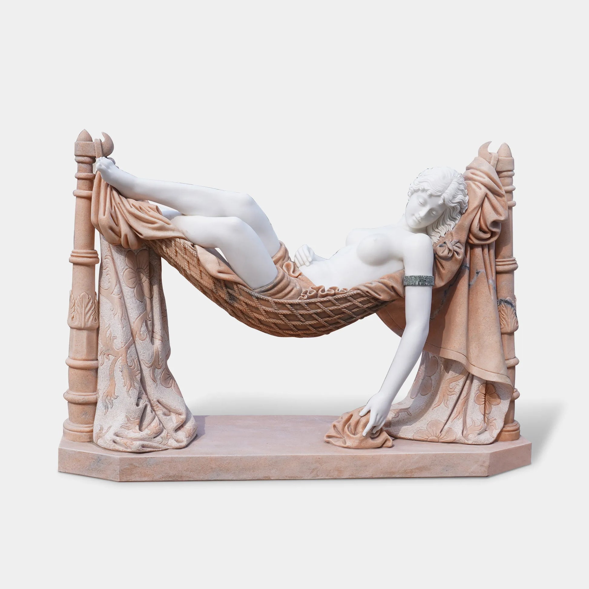 Marble sculpture of woman lying in hammock in villa garden.