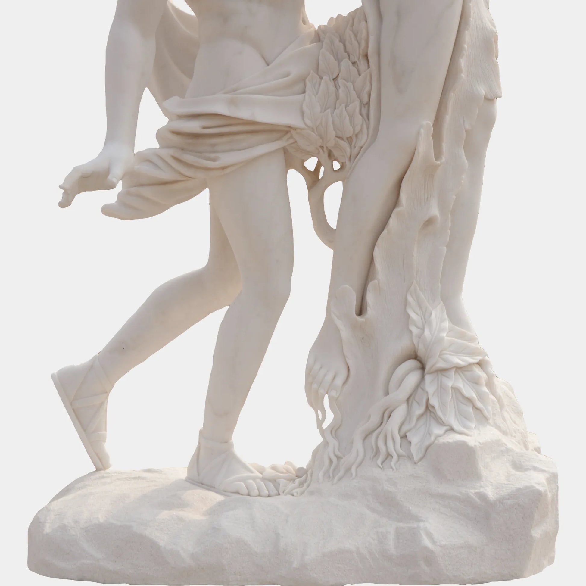 Marble sculpture of Apollo and Daphne in transformation, showing Apollo reaching for Daphne as she turns into a laurel tree, displayed outdoors in a classical courtyard with marble arches and palm trees.