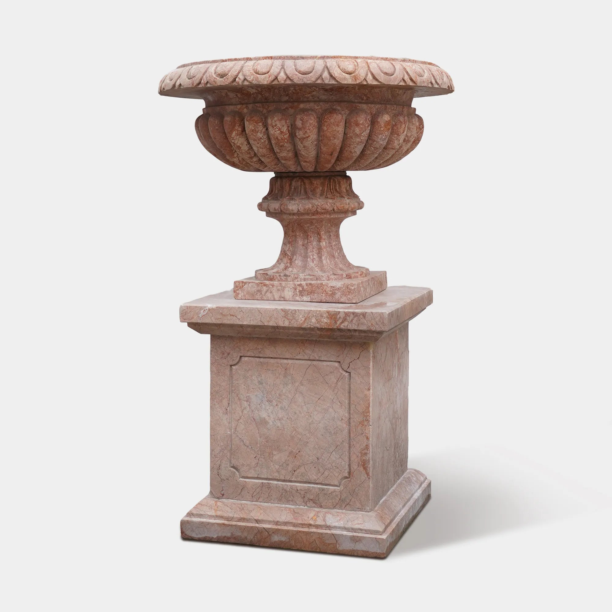 Warm-toned marble planter sculpture with elegant carved details and classic shape.