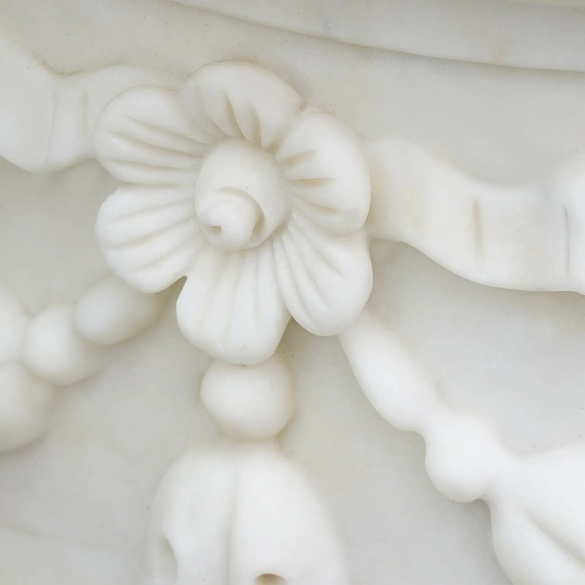 Elegant marble planter sculpture with floral motifs and rounded base design.