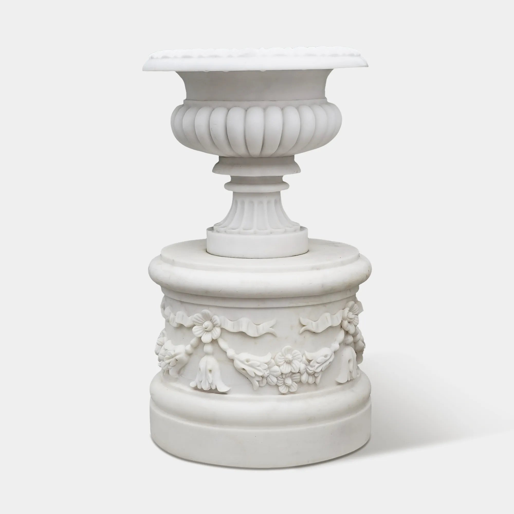 Elegant marble planter sculpture with floral motifs and rounded base design.
