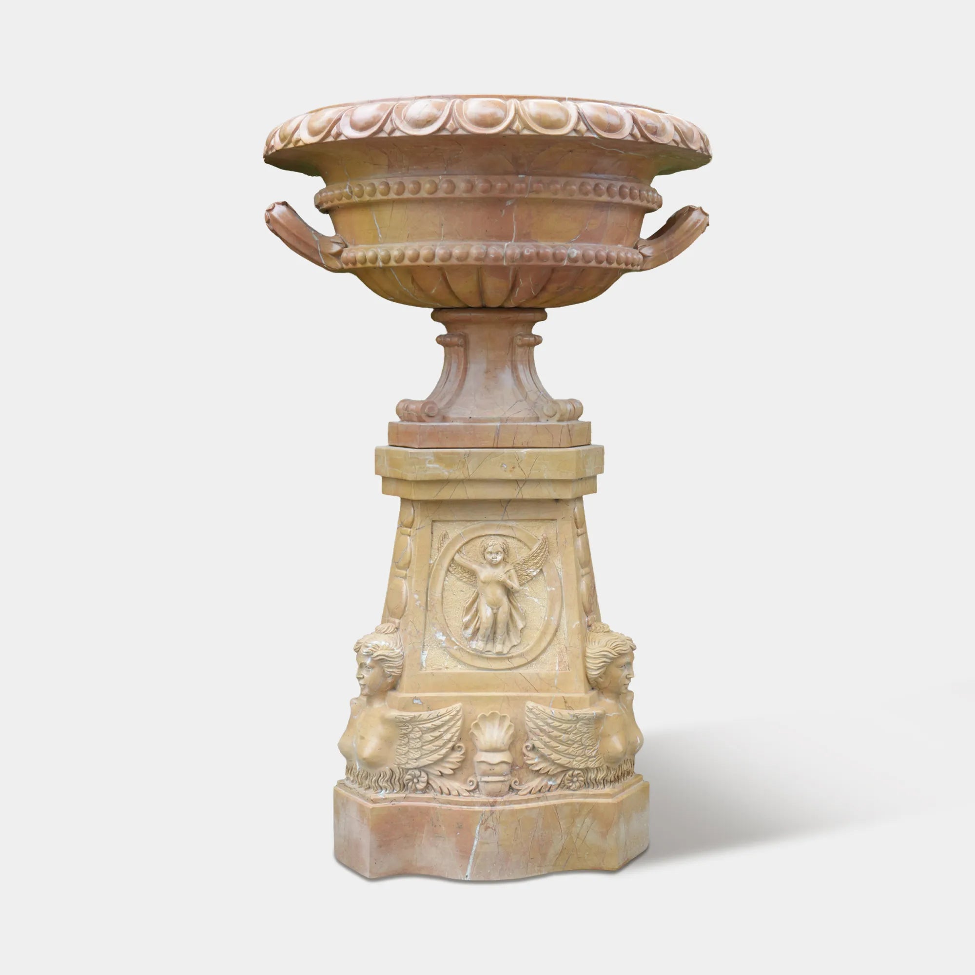 Marble planter sculpture placed near a stone villa entrance with blooming hydrangeas.