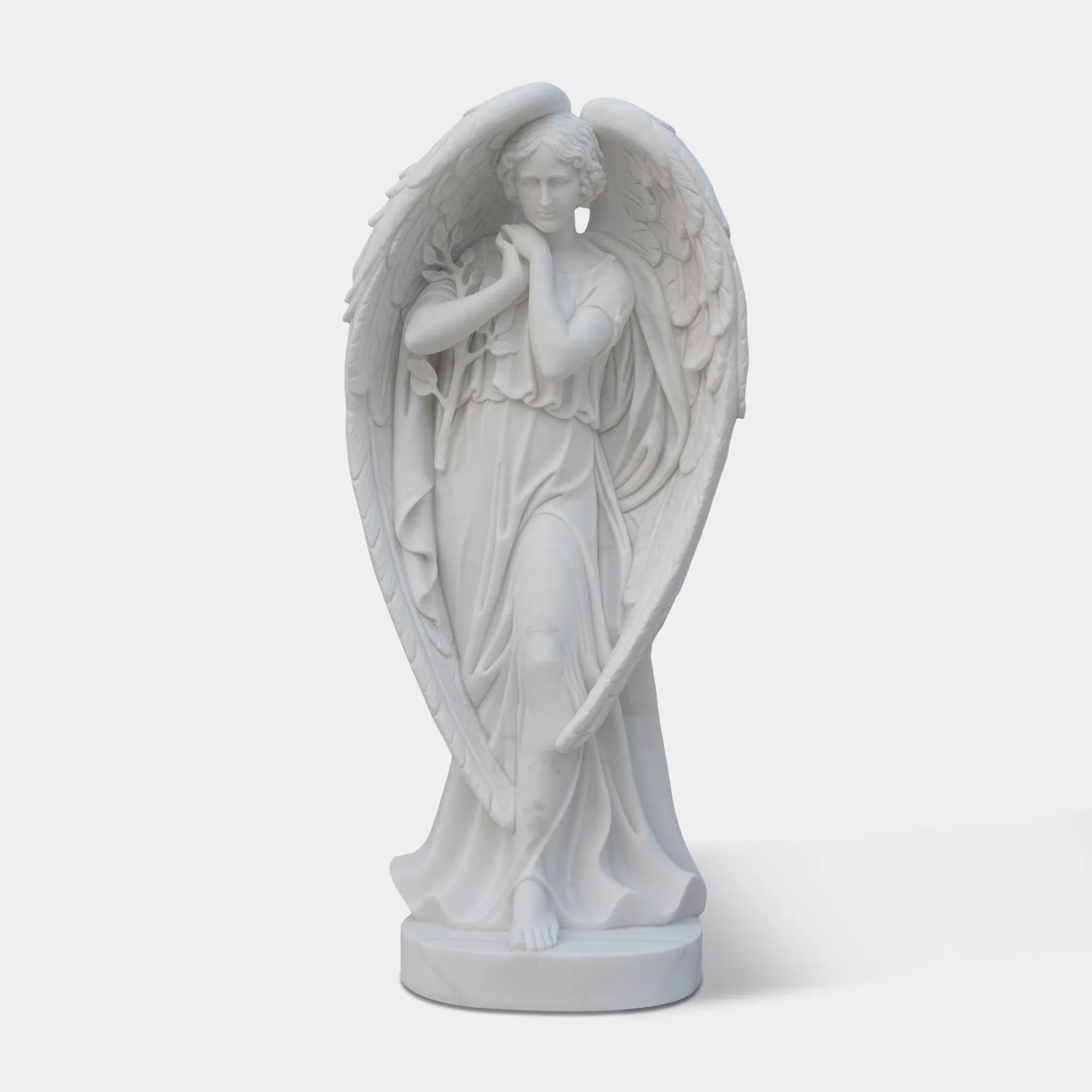 White marble angel statue standing on round base.