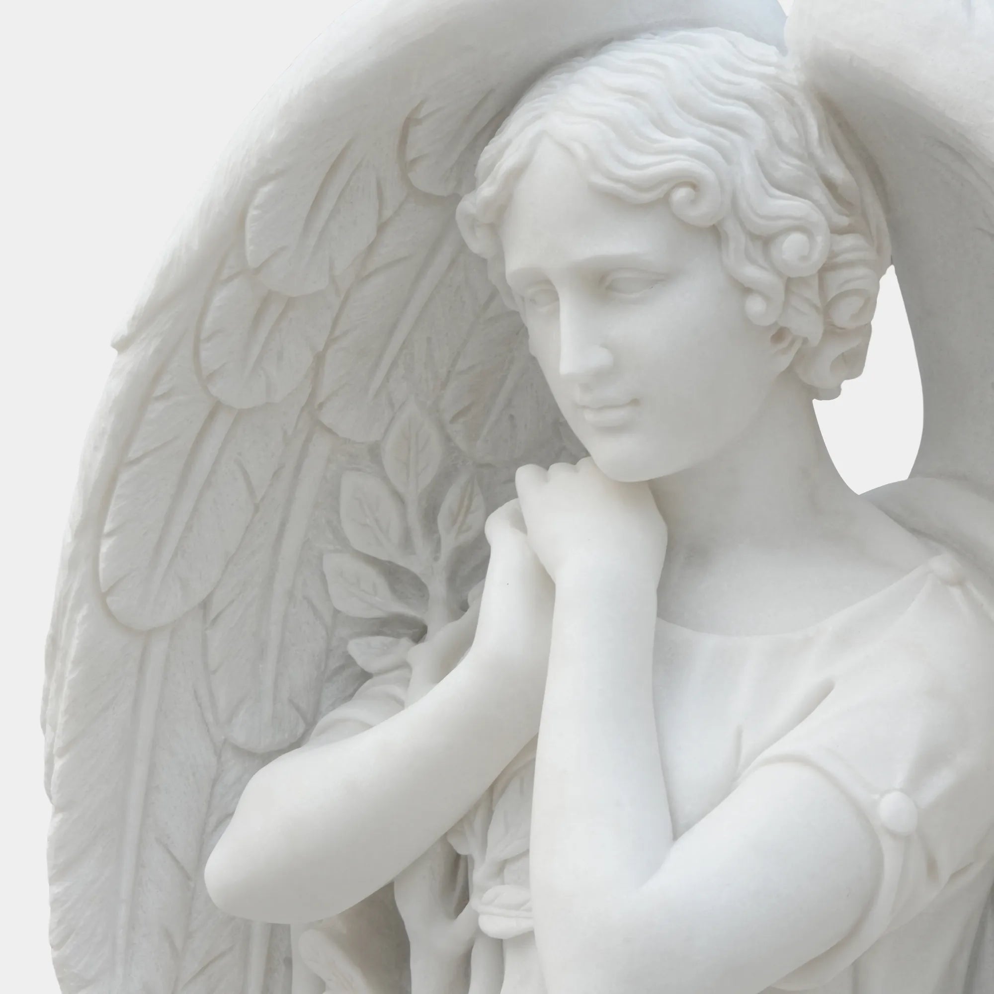 White marble angel statue standing on round base.