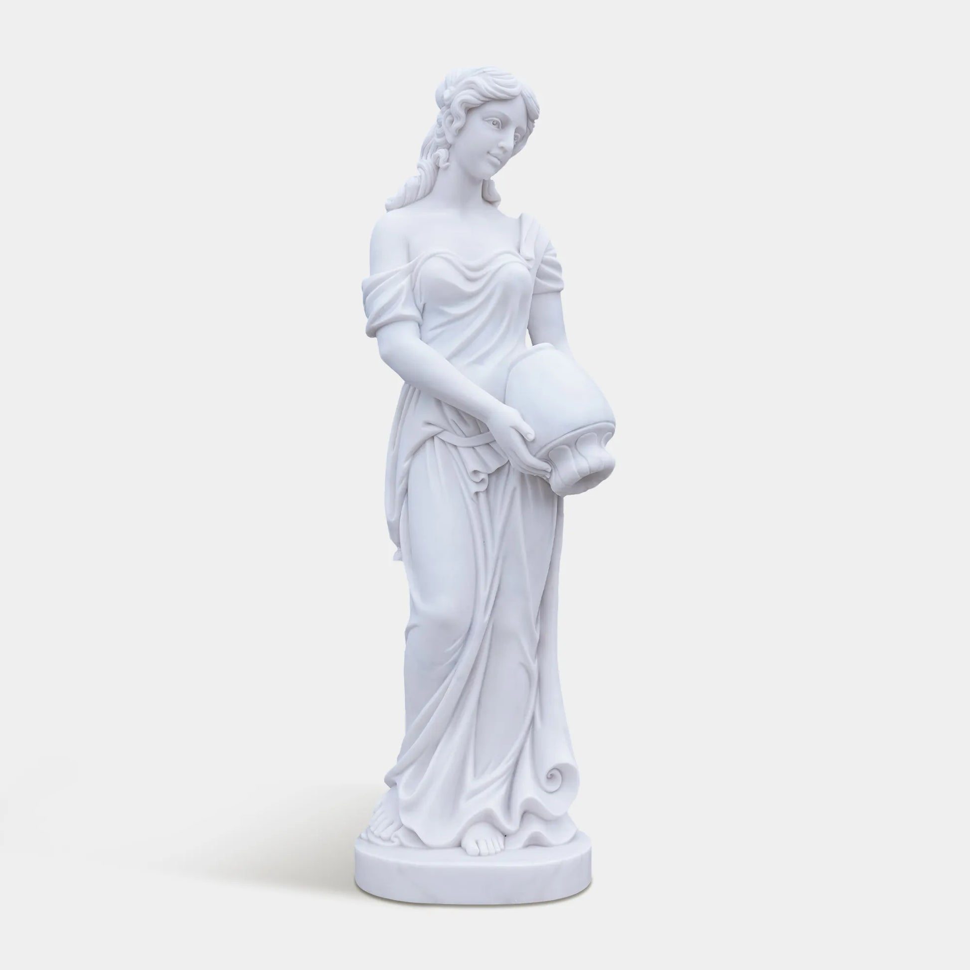 Marble female statue holding a vessel in a garden setting.