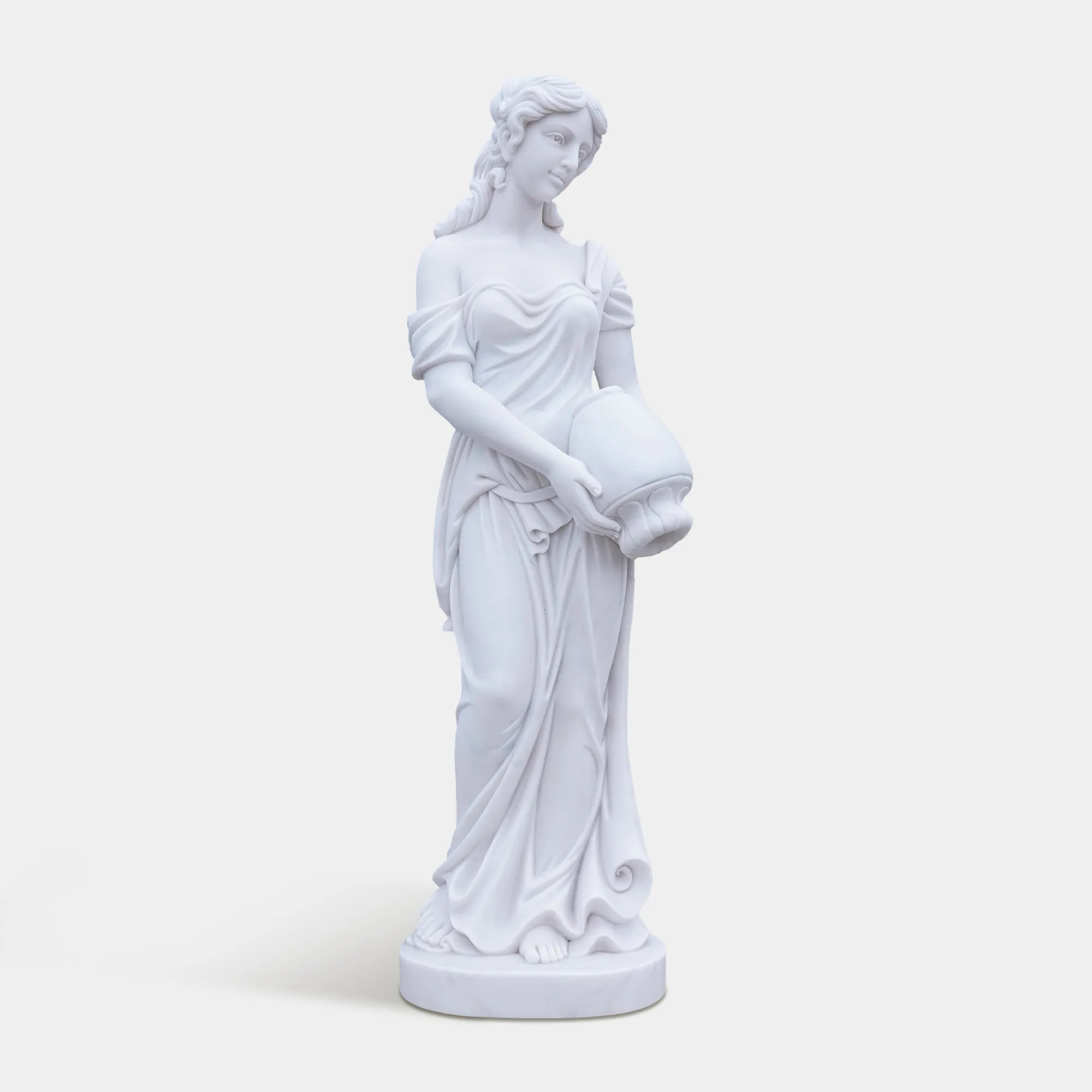 Marble female statue holding a vessel in a garden setting.