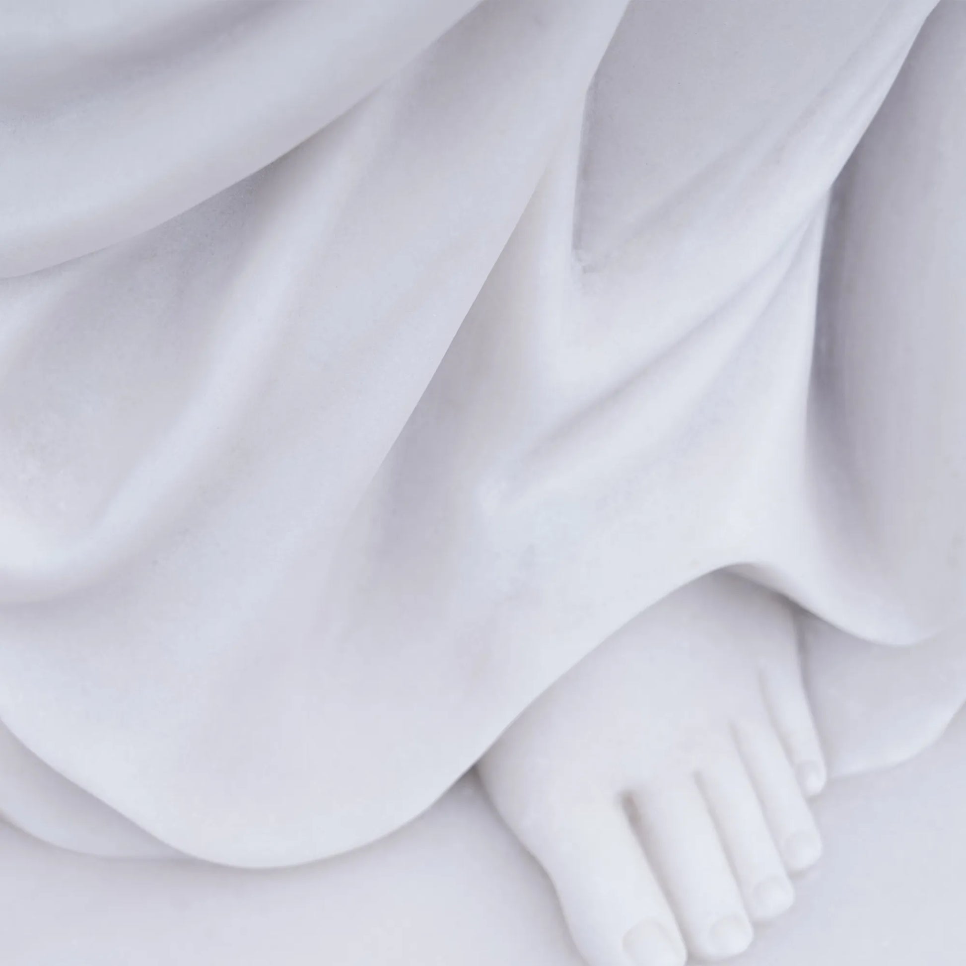 Marble female statue holding a vessel in a garden setting.