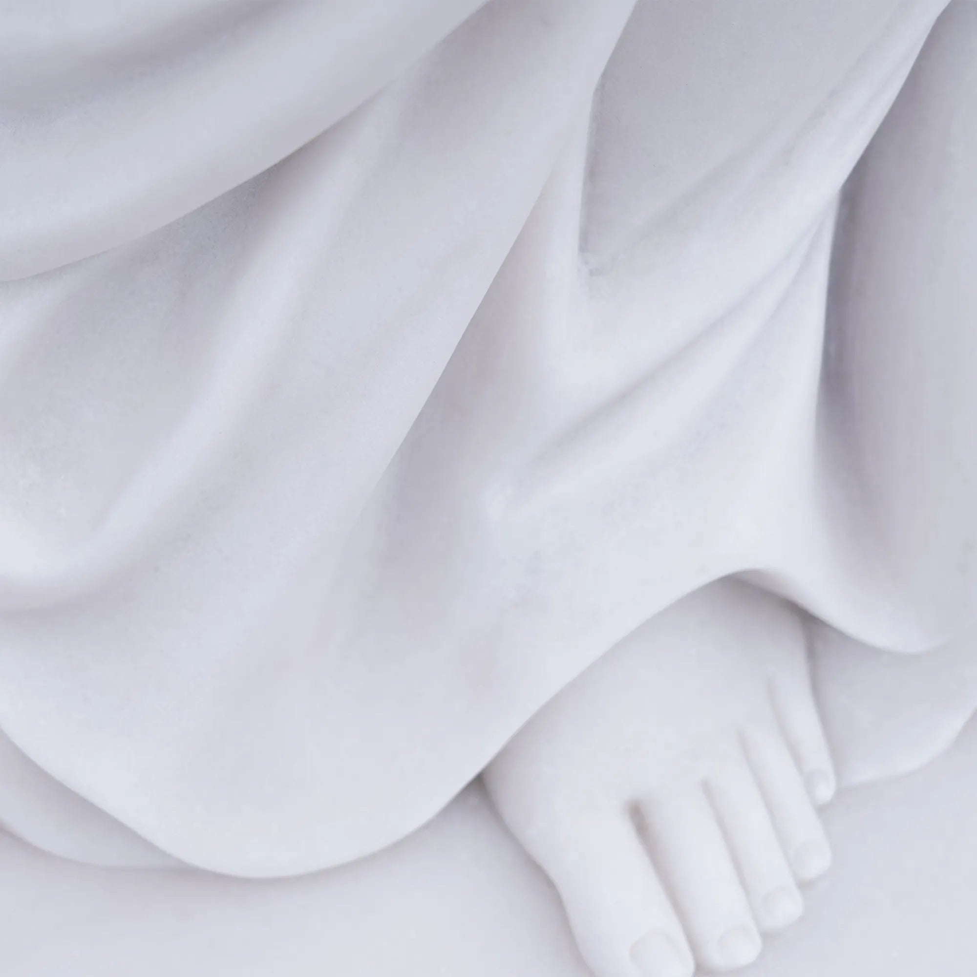 Marble female statue holding a vessel in a garden setting.