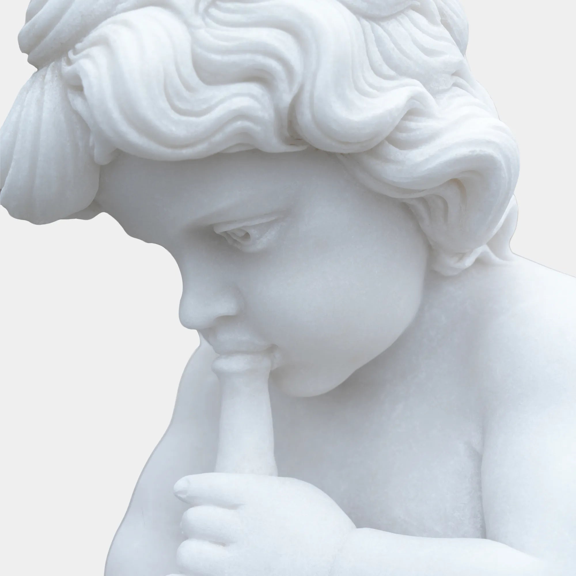 White marble cherub angel statue playing a flute on a pedestal in the garden path. 