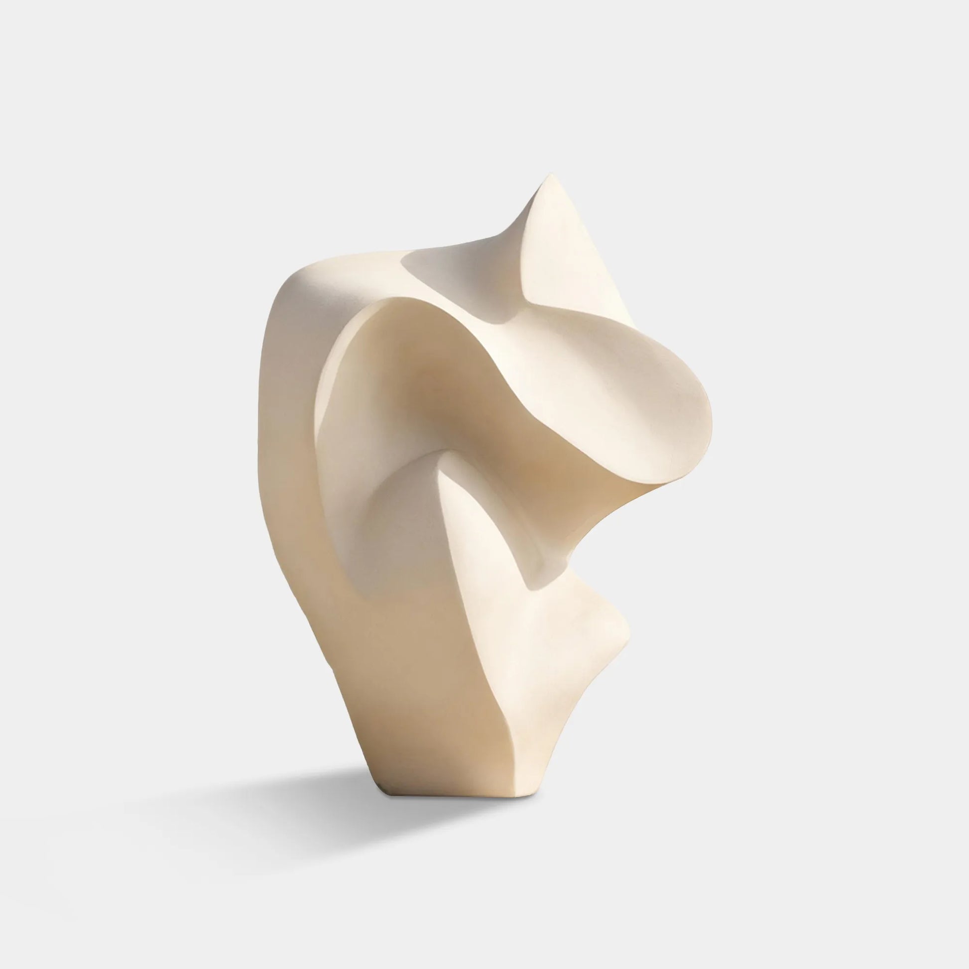 Abstract stainless steel sculpture with smooth curved form on pedestal.