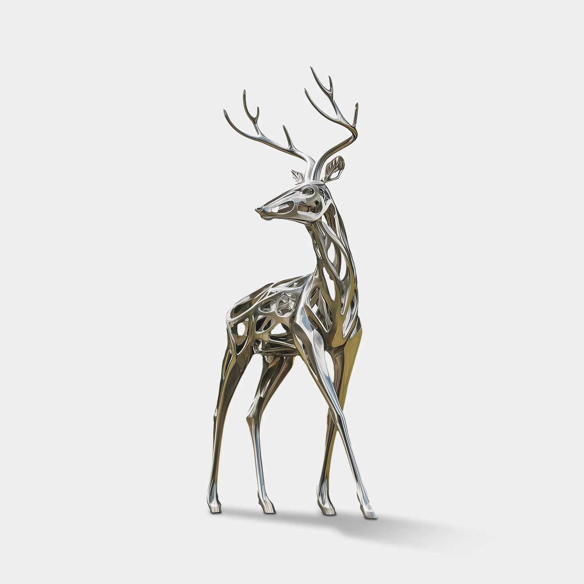 Polished stainless steel deer sculpture with antlers in outdoor park setting.