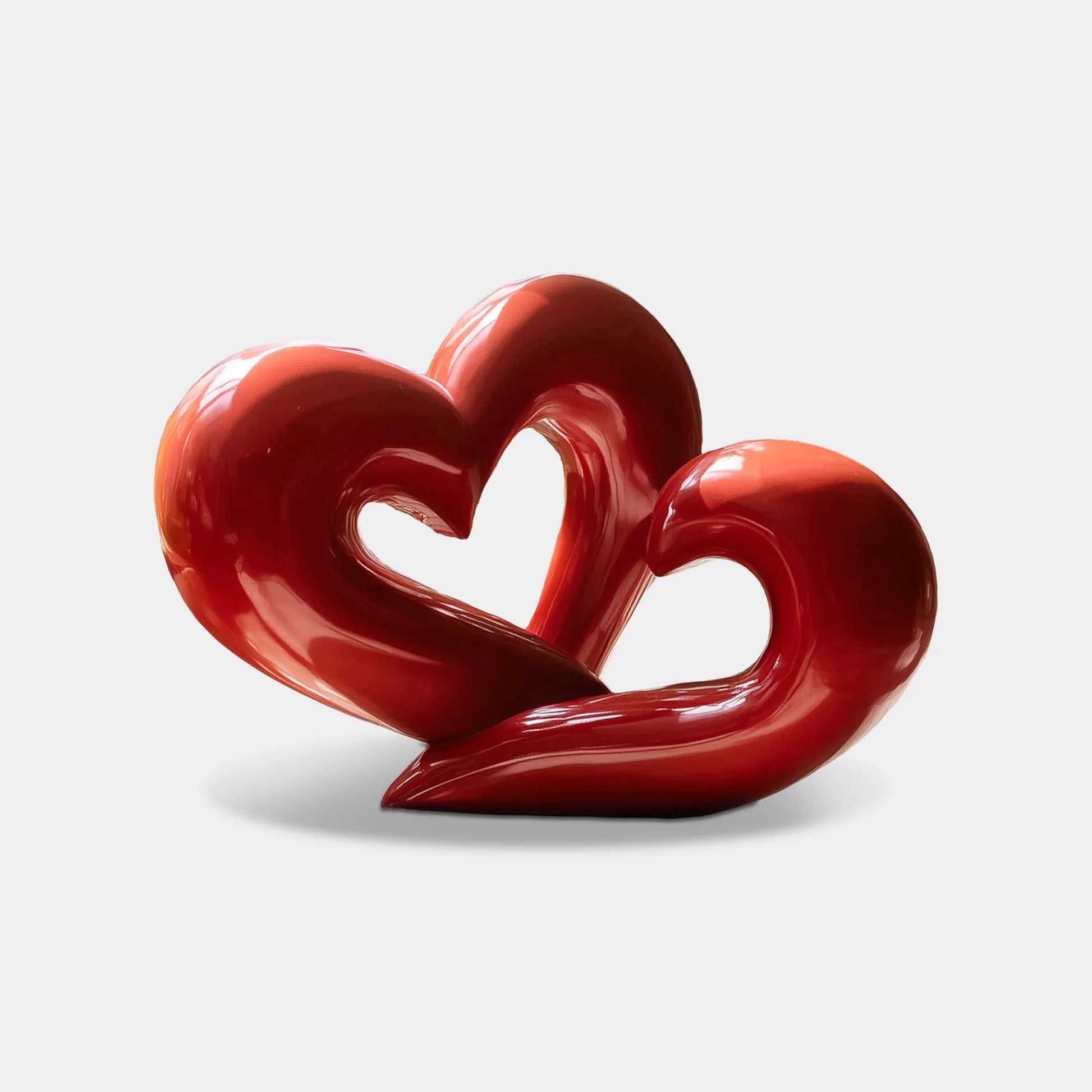 Heart-shaped stainless steel abstract sculpture with a glossy painted finish, displayed in a contemporary indoor space with clean lines and soft lighting.