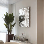 Modern silver stainless steel wall sculpture with ripple effect design for homes, offices, and luxury interiors.