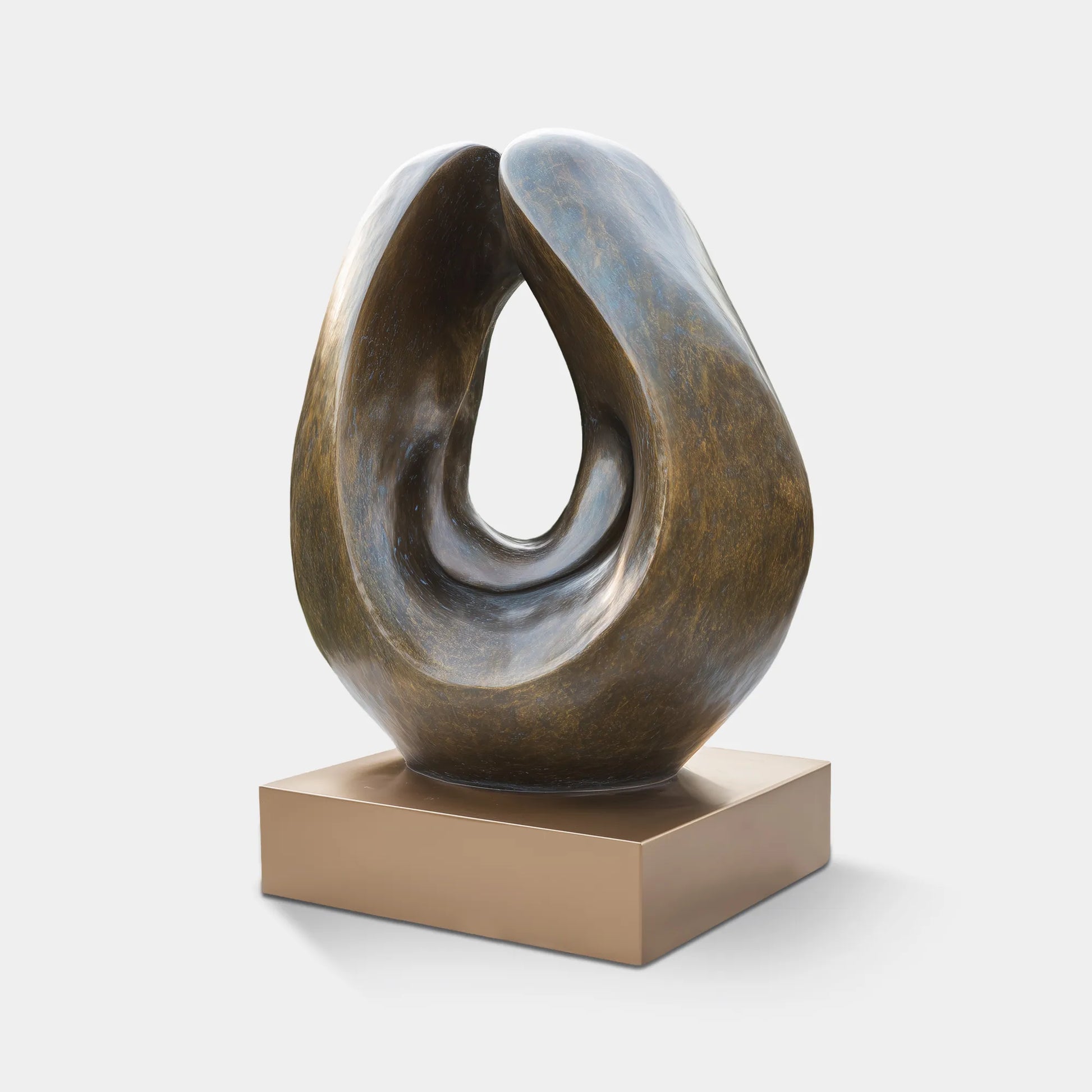 Bronze abstract sculpture with an open shape displayed outdoors.