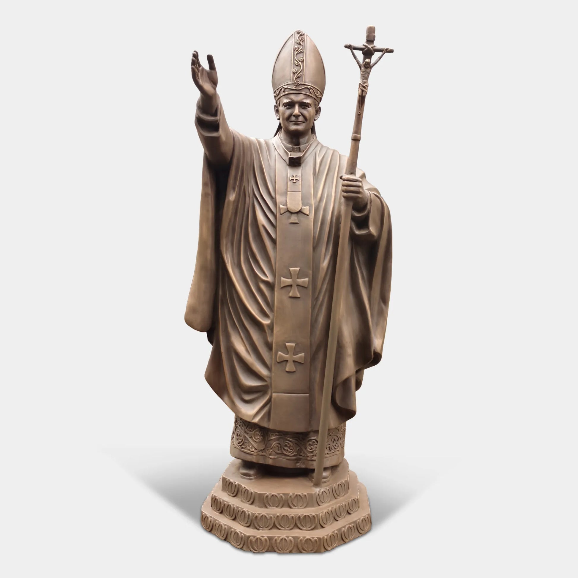 Bronze statue of a religious leader raising a hand in blessing.