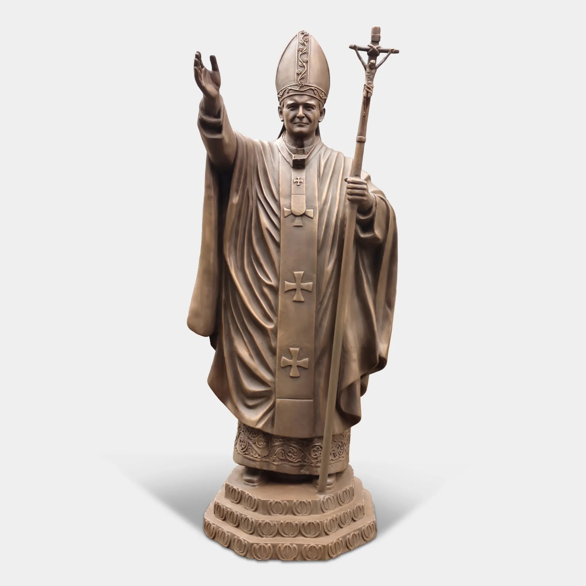 Bronze statue of a religious leader raising a hand in blessing.