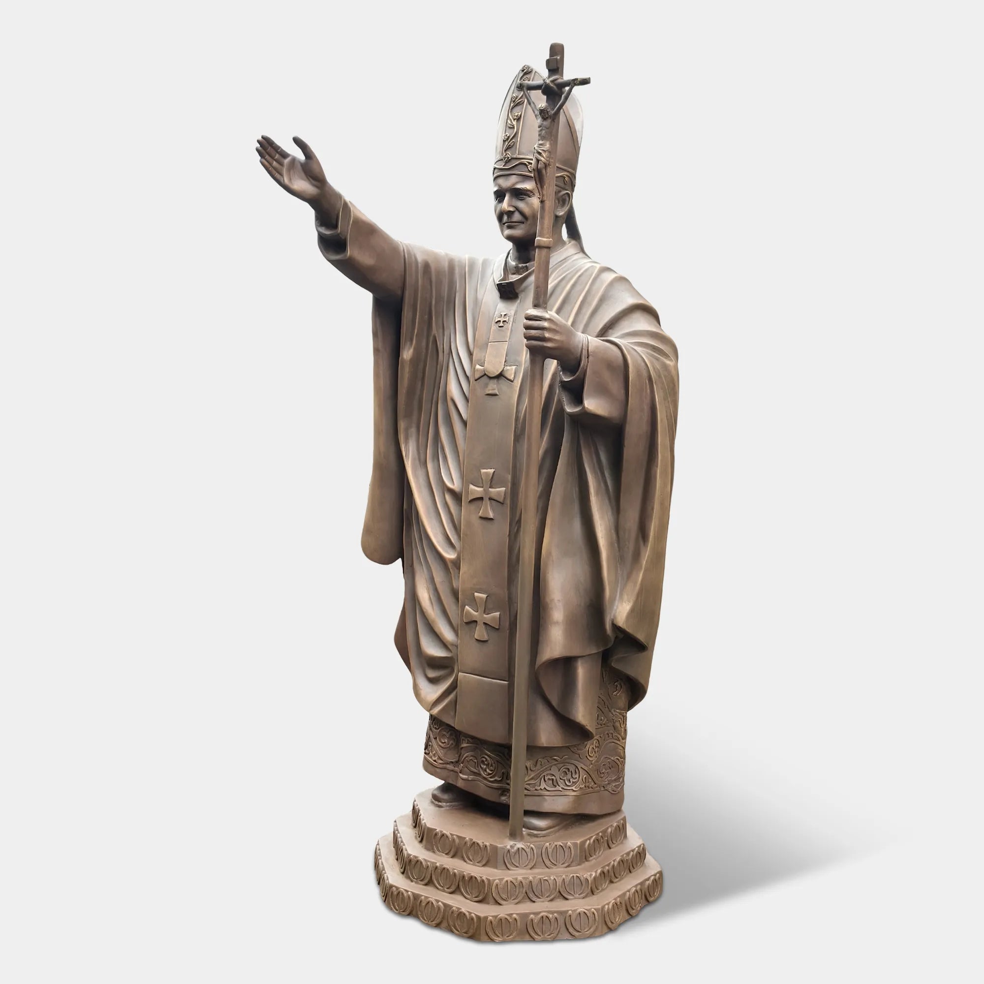 Bronze statue of a religious leader raising a hand in blessing.