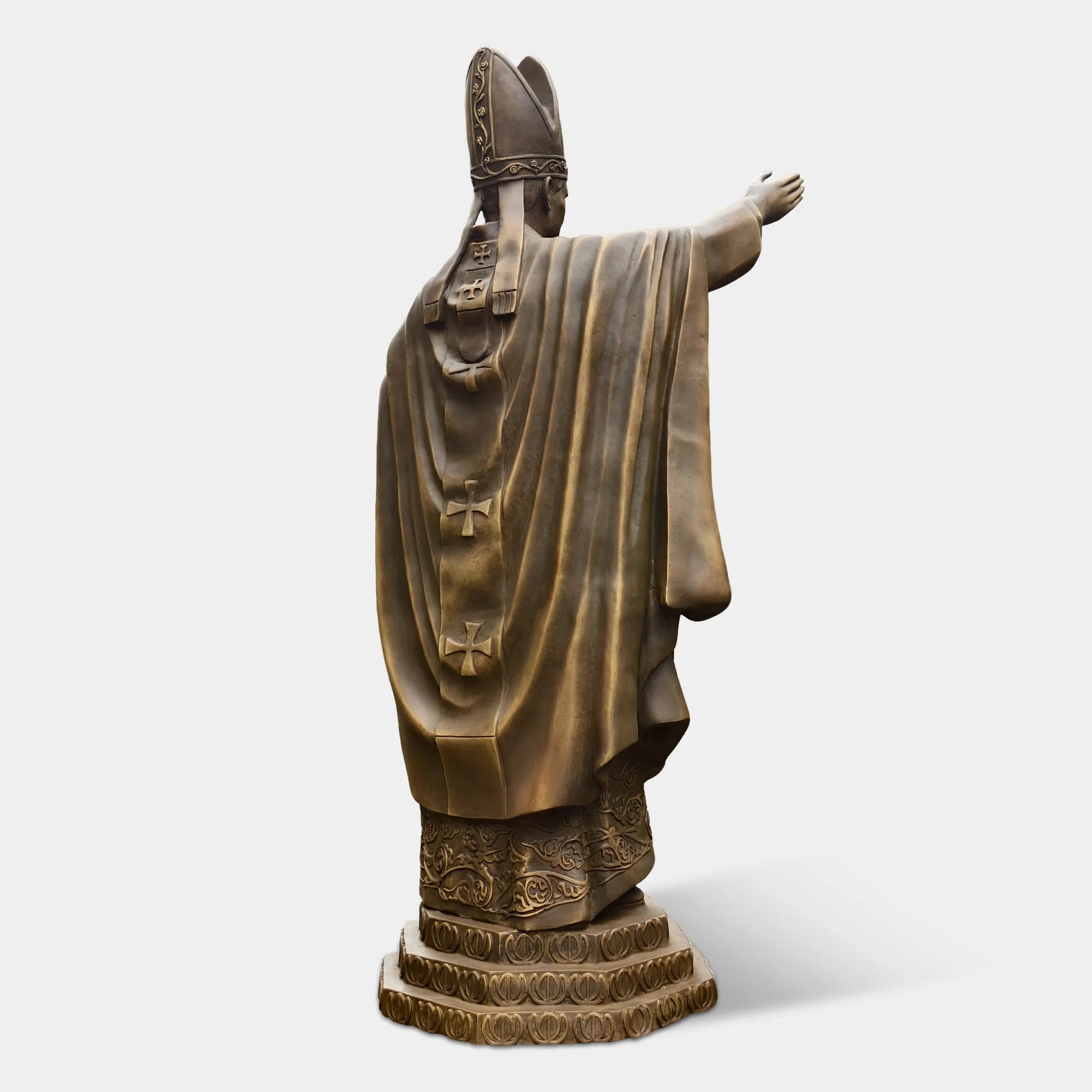 Bronze statue of a religious leader raising a hand in blessing.