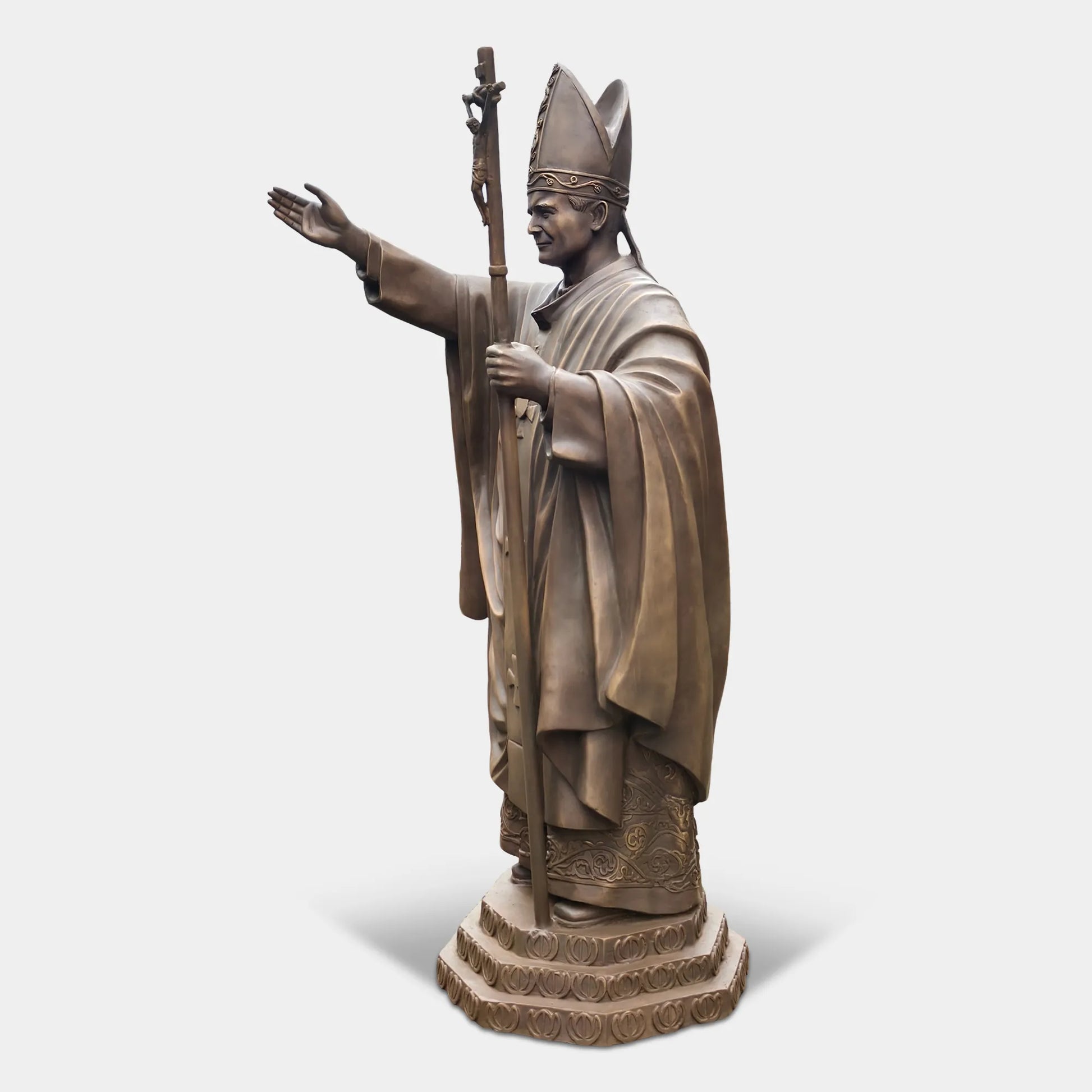 Bronze statue of a religious leader raising a hand in blessing.