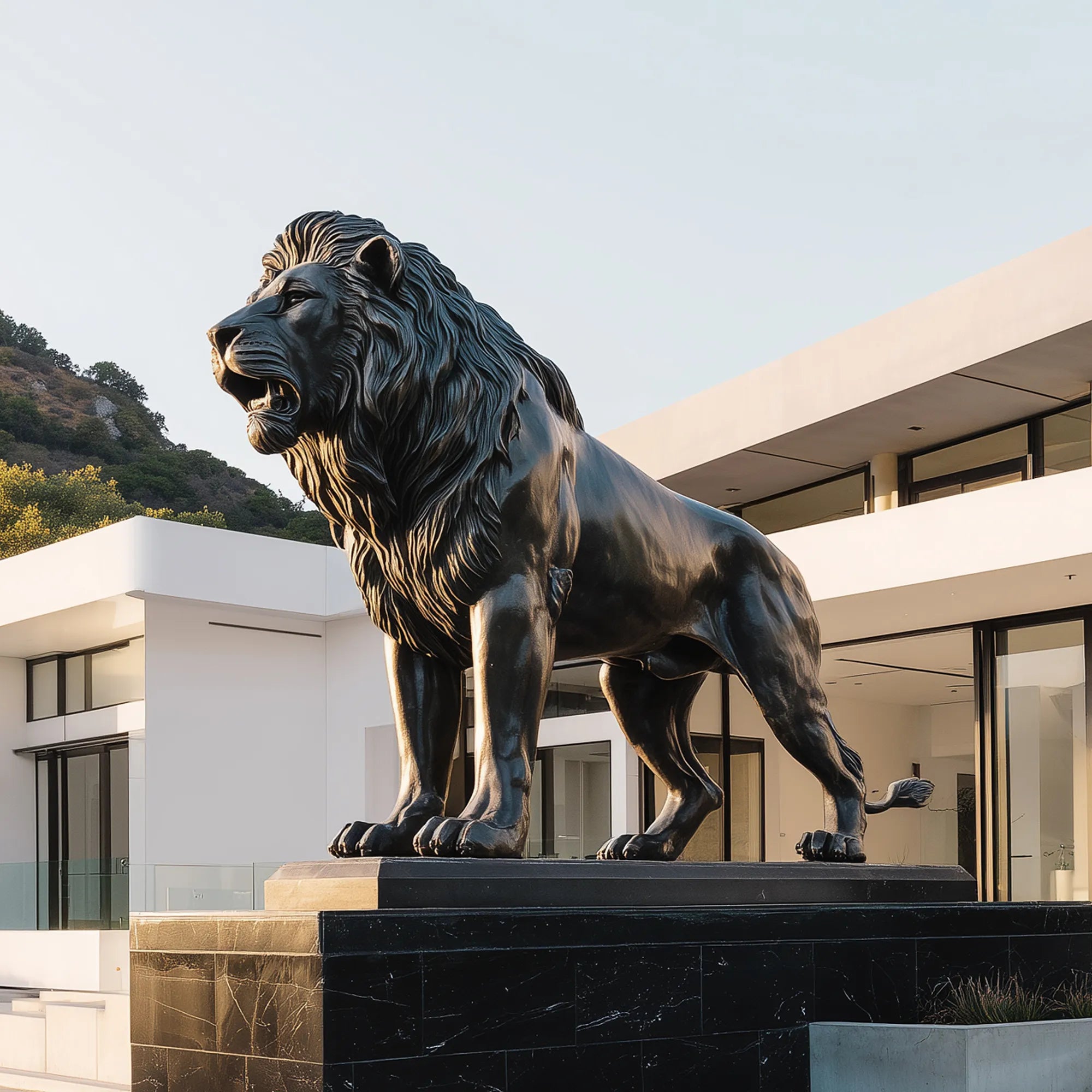 Large dark bronze lion sculpture standing on a black stone base in front of a modern luxury villa exterior.