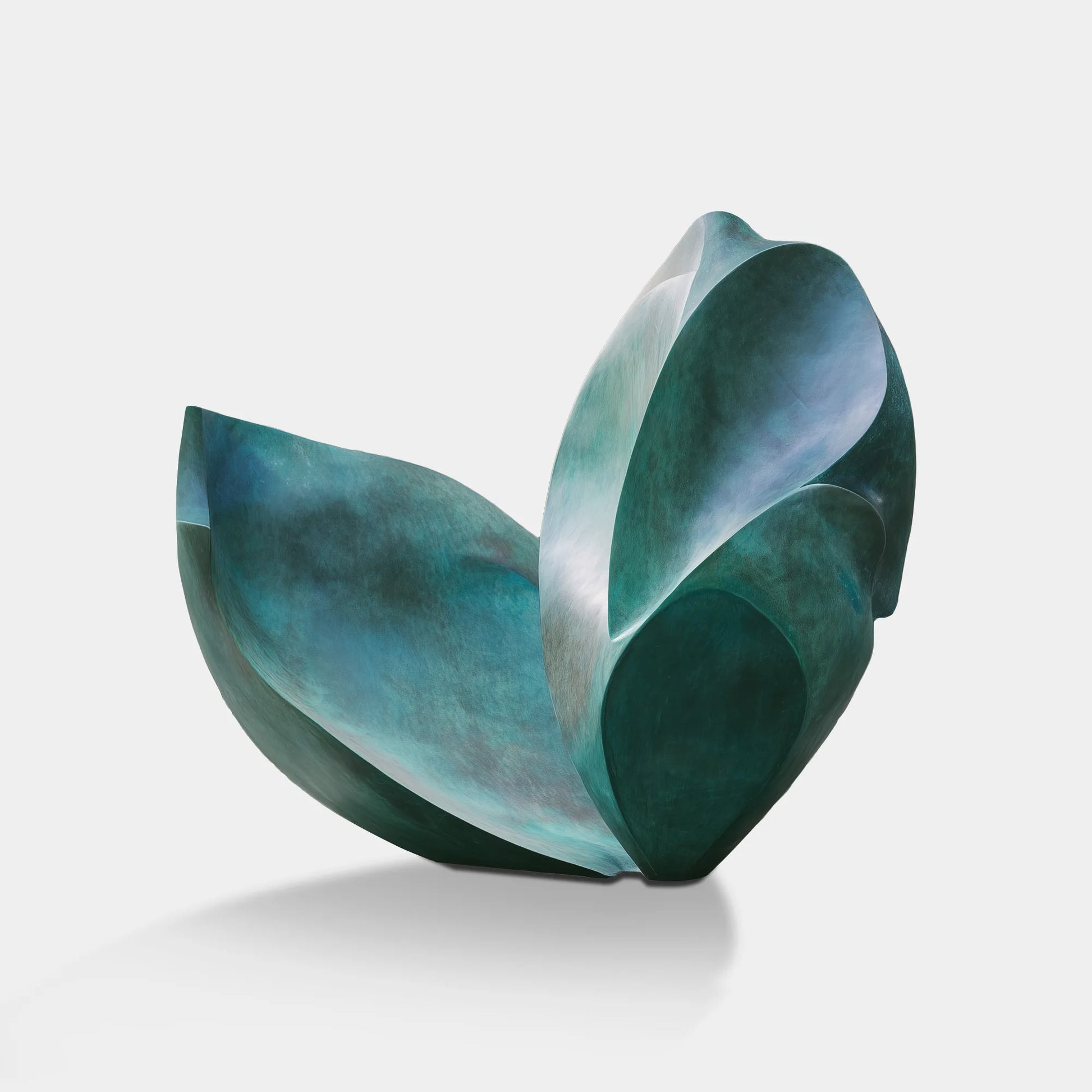 Abstract bronze organic form sculpture on stone base in corporate lobby atrium with glass walls and water feature