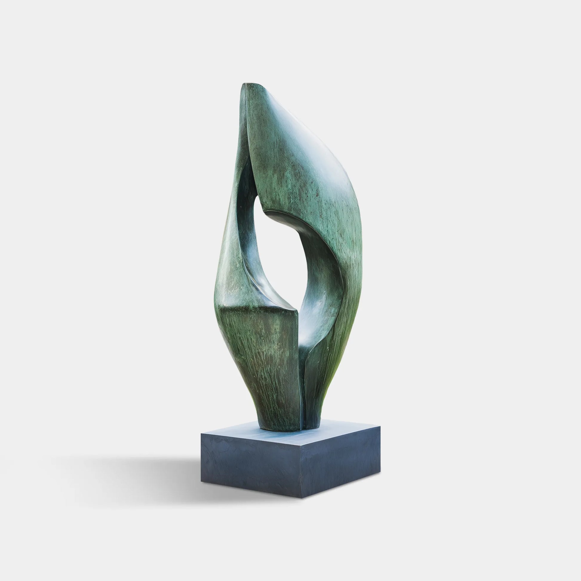 Abstract patinated bronze sculpture with flowing curved form and hollow center on square pedestal in gravel courtyard