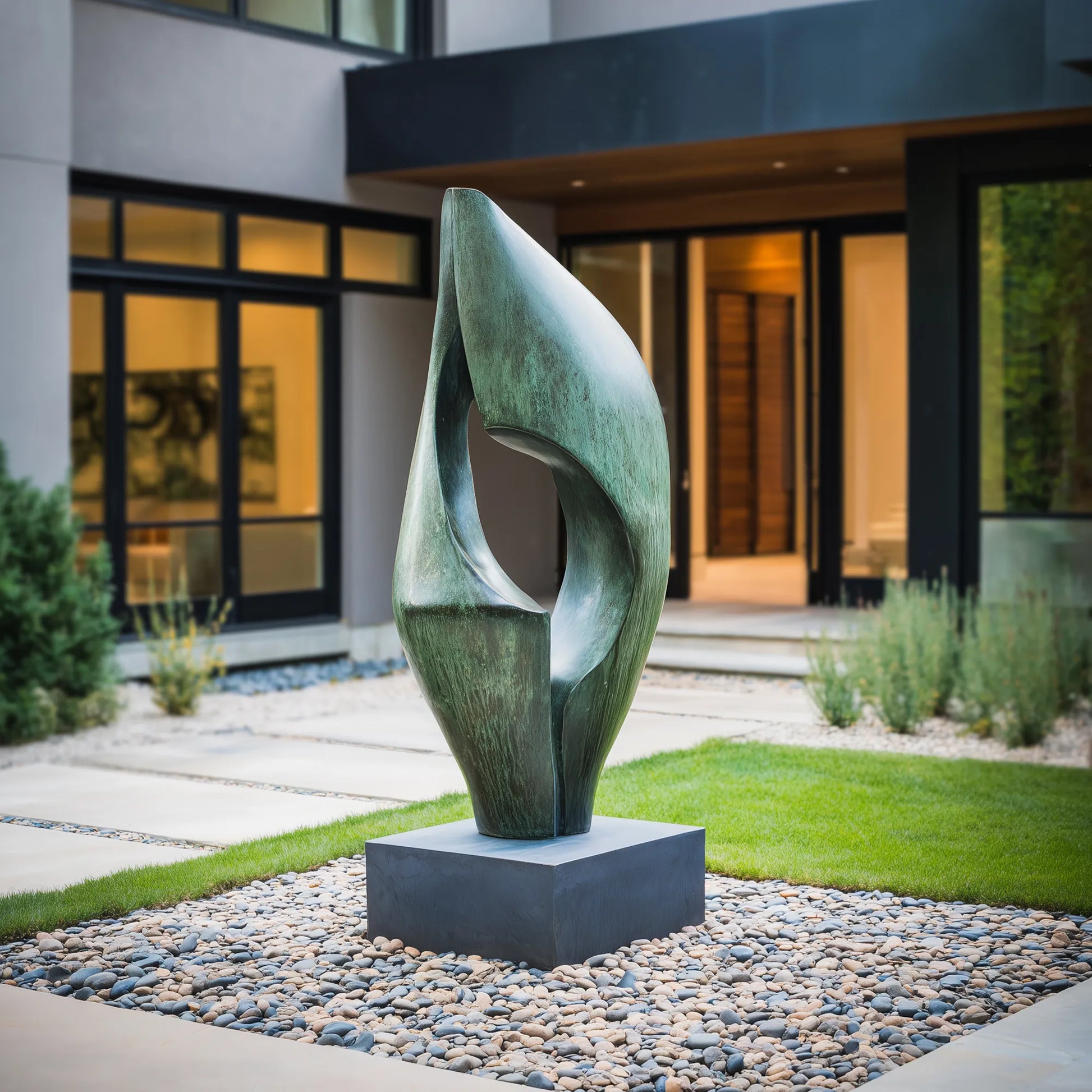 Abstract patinated bronze sculpture with flowing curved form and hollow center on square pedestal in gravel courtyard