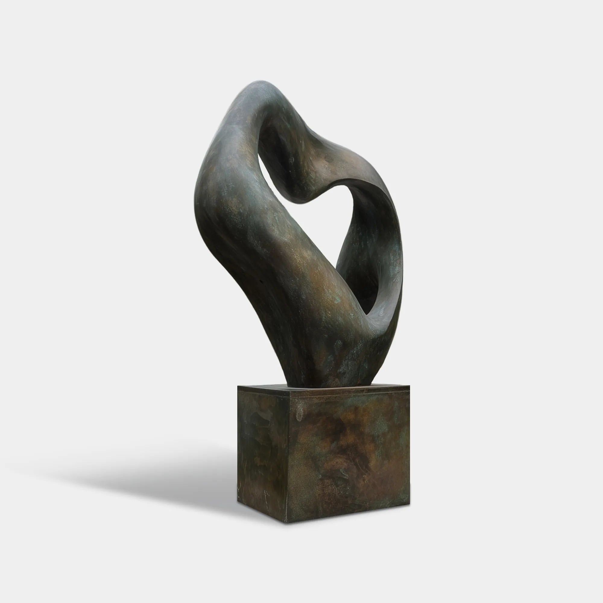 Patinated bronze organic form sculpture in a modern concrete courtyard surrounded by forest landscaping and glass architecture.
