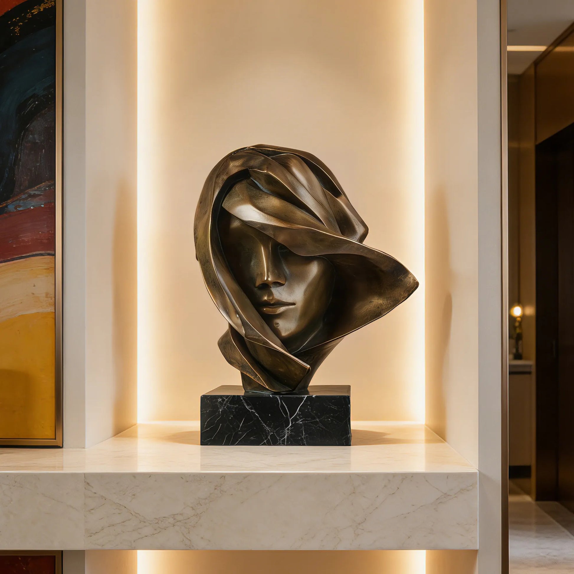 An elegant bronze female bust sculpture rests on a marble shelf with warm backlight and abstract wall art beside it.