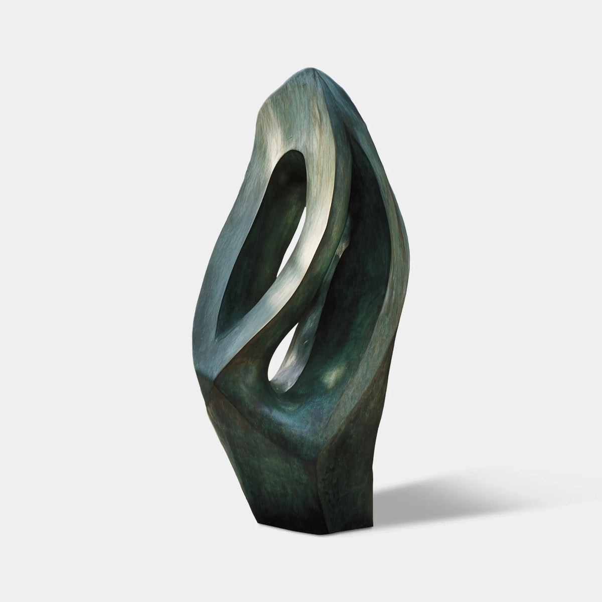 Large green bronze organic sculpture with layered openings and folded surfaces in a modern villa garden courtyard.