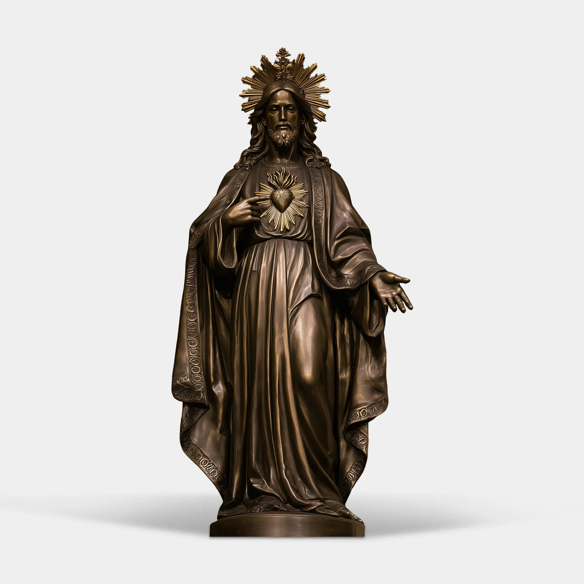 A bronze sacred heart Jesus statue sits inside an ornate golden arched niche.