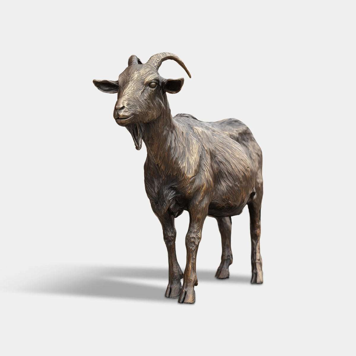 Bronze standing goat statue beside an outdoor entrance gate.