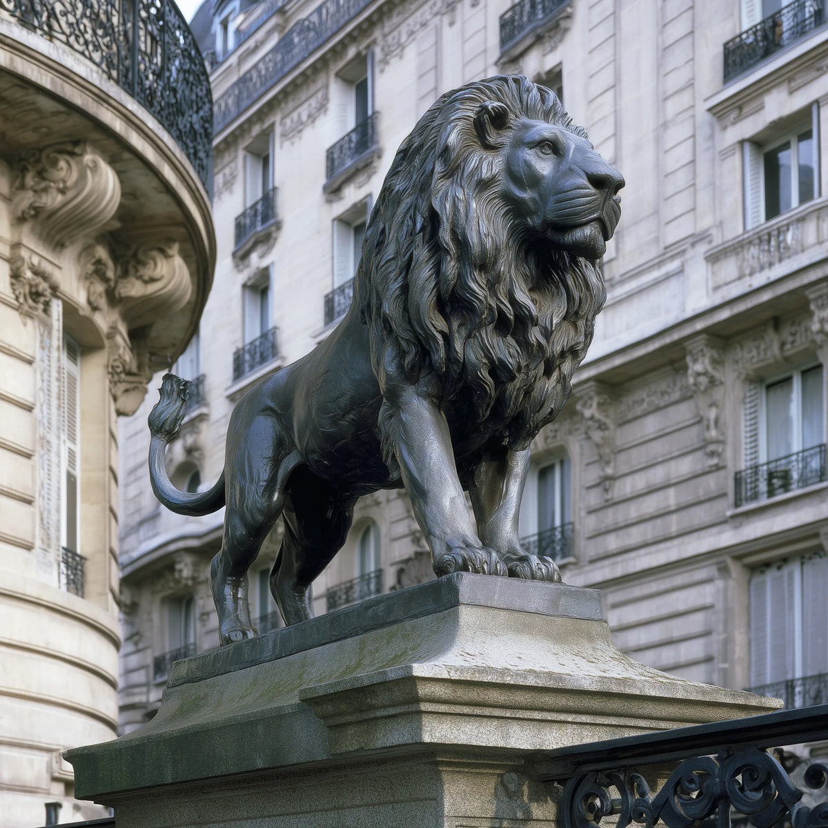 Dark bronze standing lion statue with a detailed flowing mane, muscular body, and curved tail.