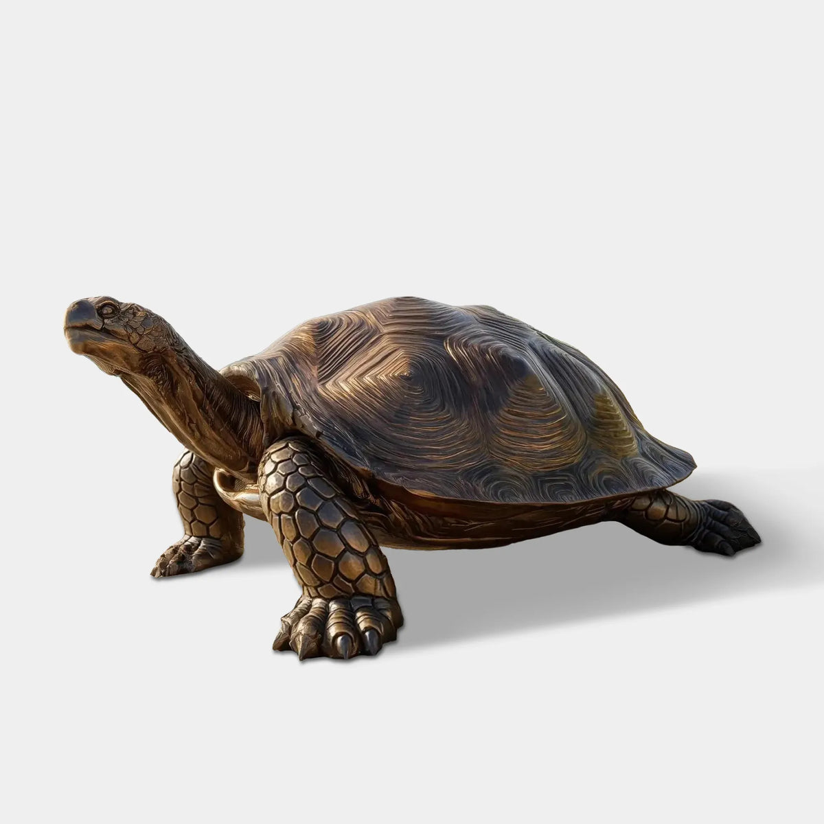 Bronze turtle statue with a textured shell, detailed legs, and raised head on a sandy beach with palm trees and ocean