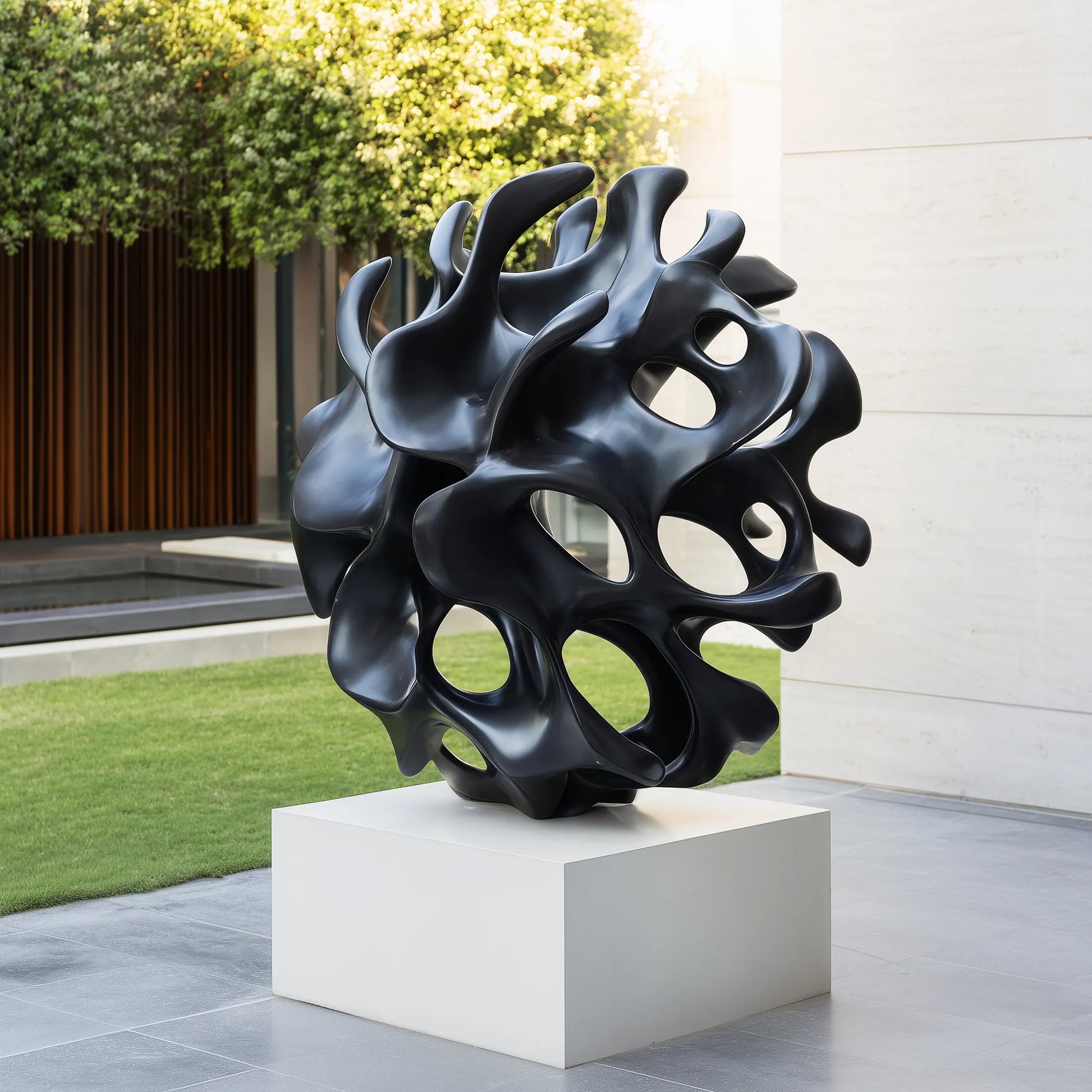 Matte black organic hollow abstract bronze sculpture in modern courtyard lawn