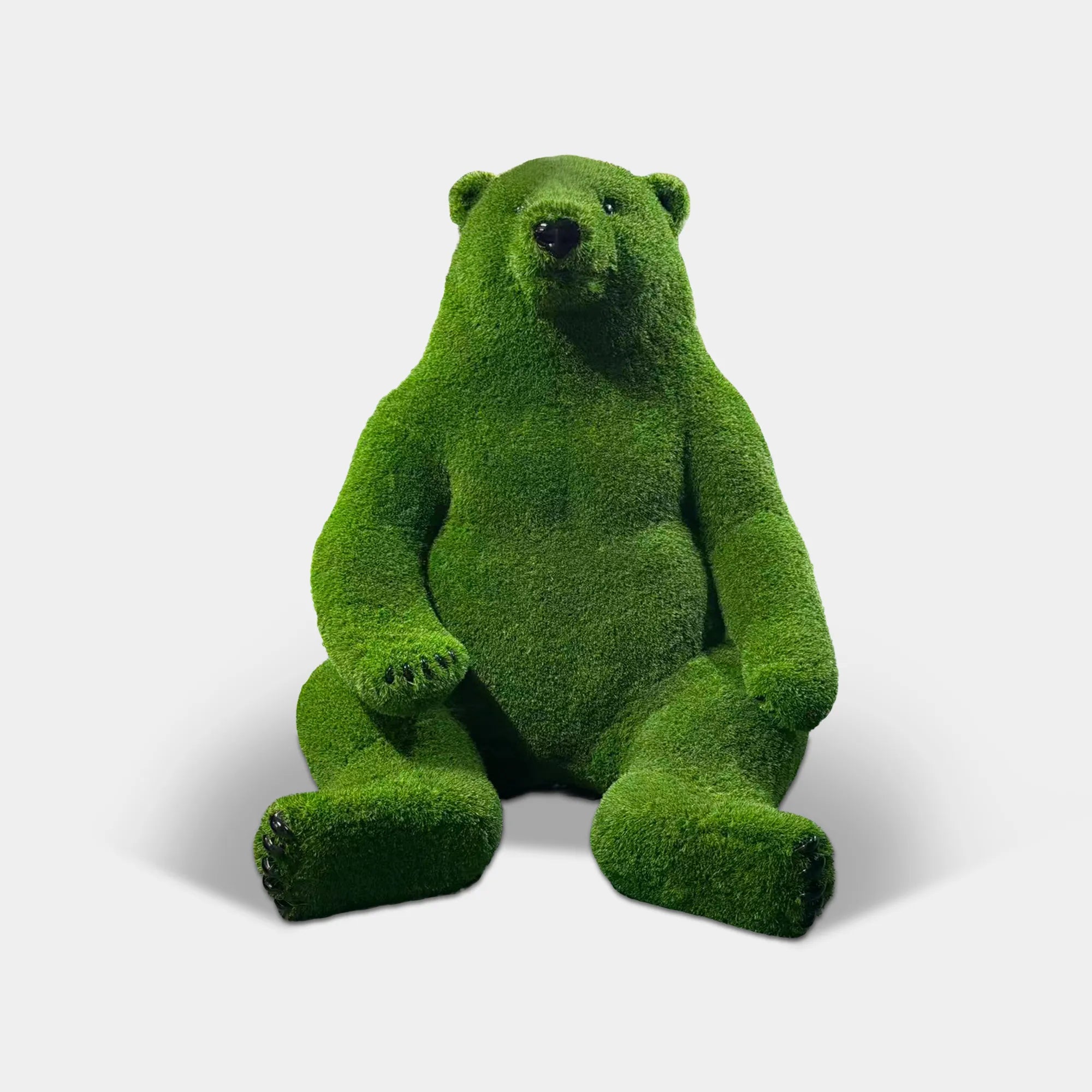 Fuzzy fiberglass bear statue sitting on floor with soft textured surface and rounded form in an art gallery.