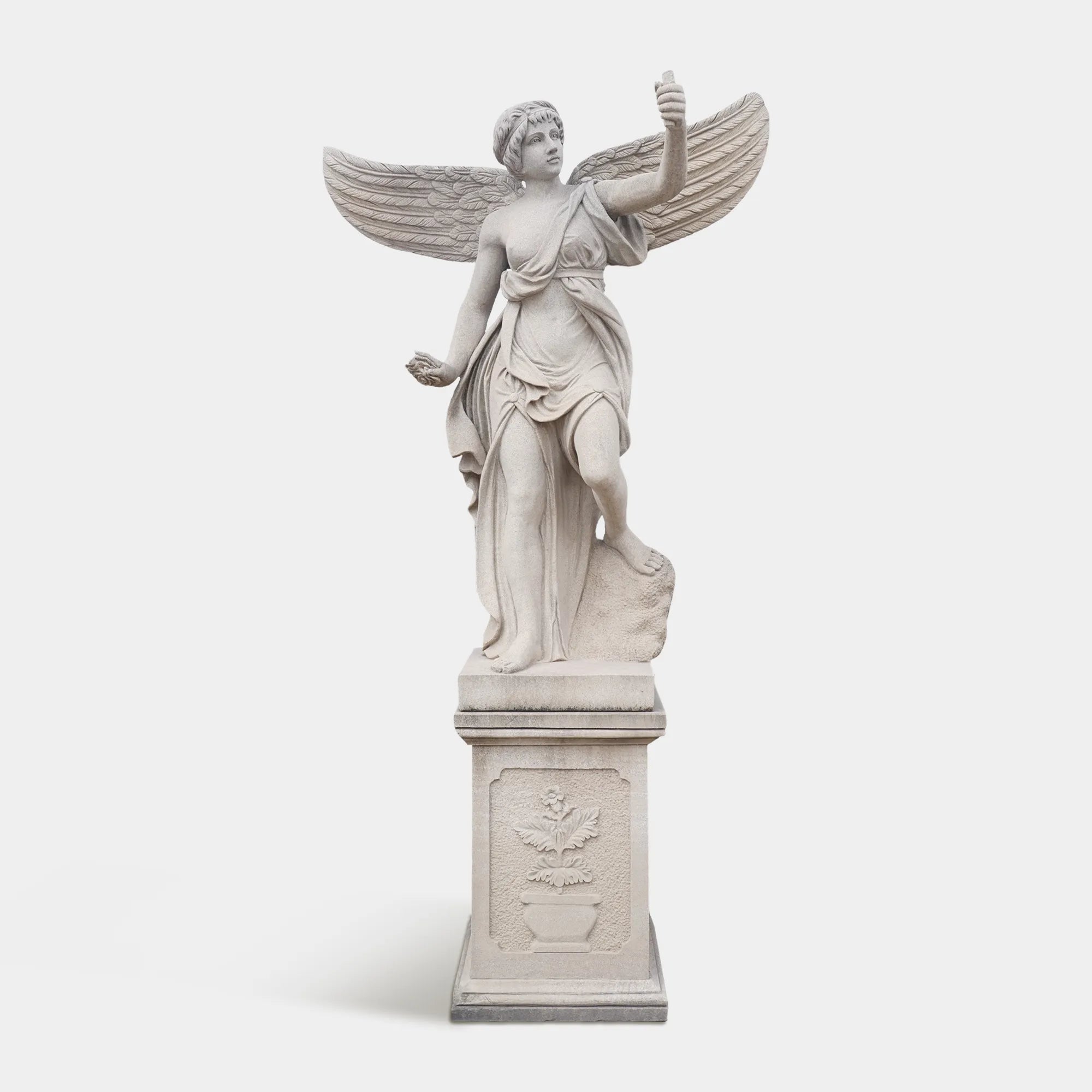 A marble angel statue on a pedestal in a luxurious villa garden. 