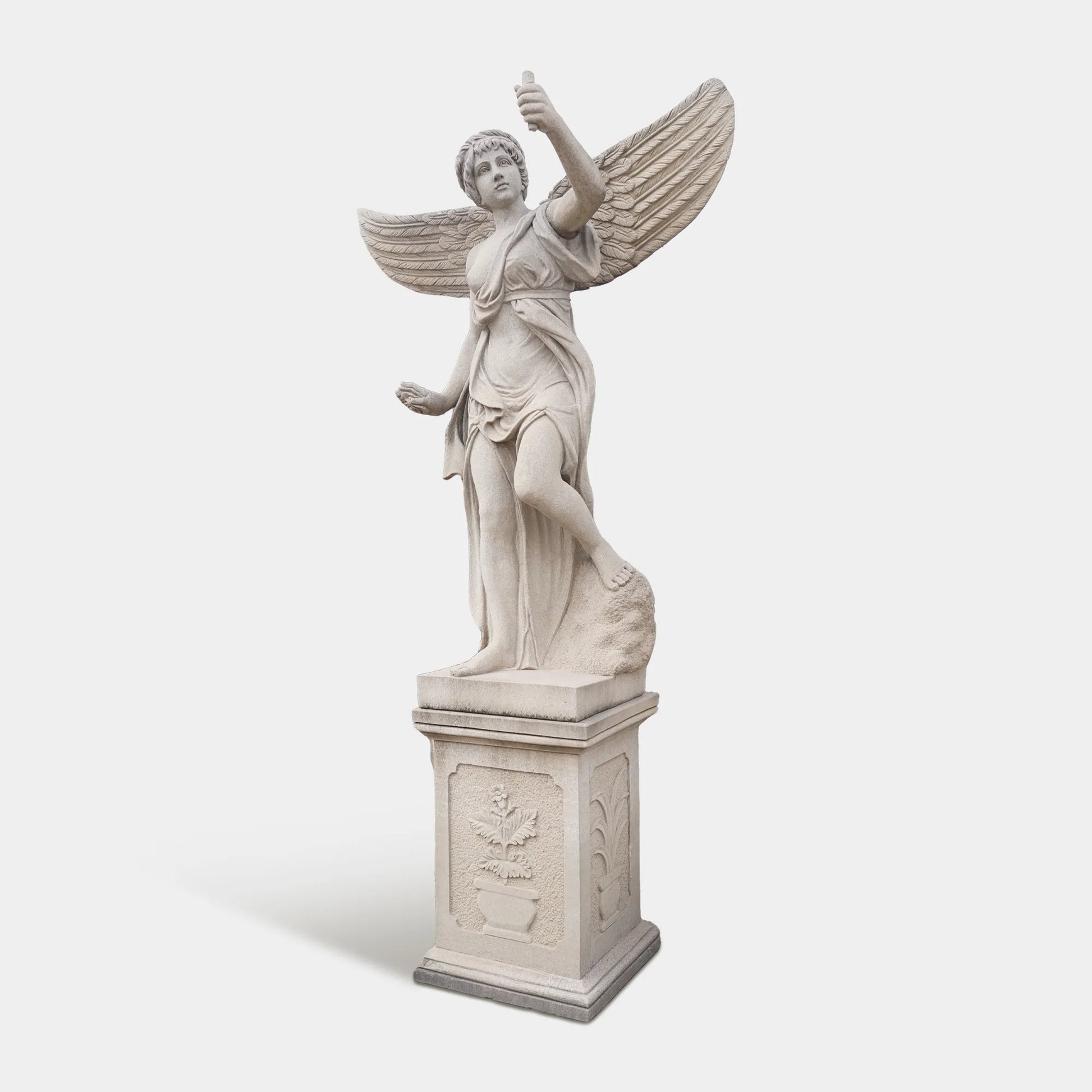 A marble angel statue on a pedestal in a luxurious villa garden. 