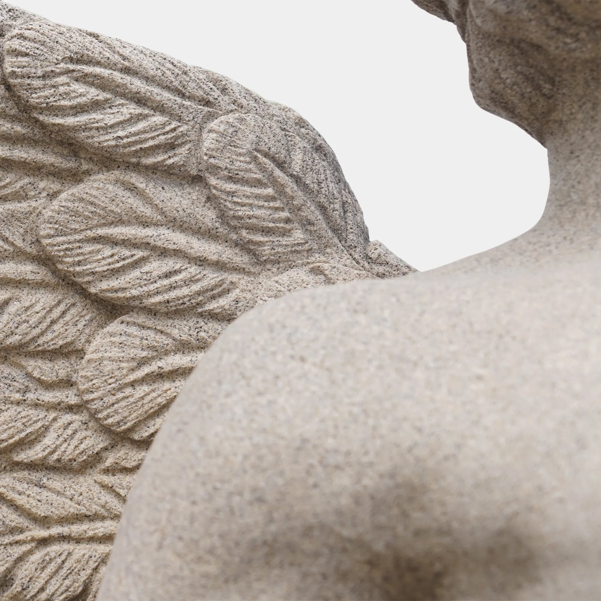 A marble angel statue on a pedestal in a luxurious villa garden. 