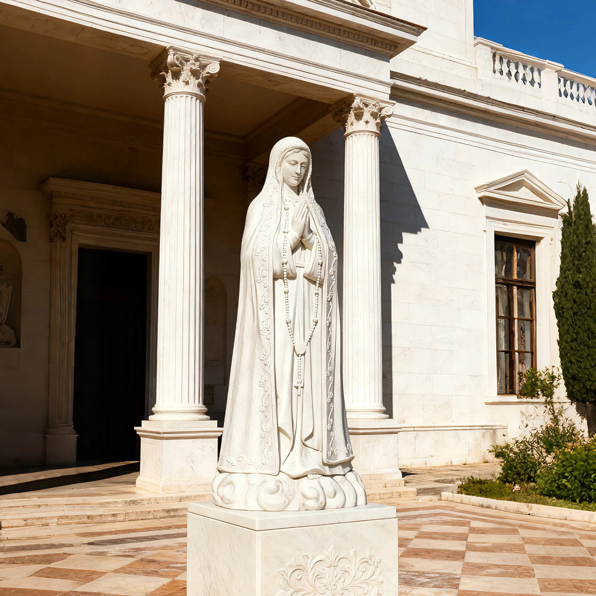 Our Lady of Fátima marble statue in front of a church with delicate carved details.