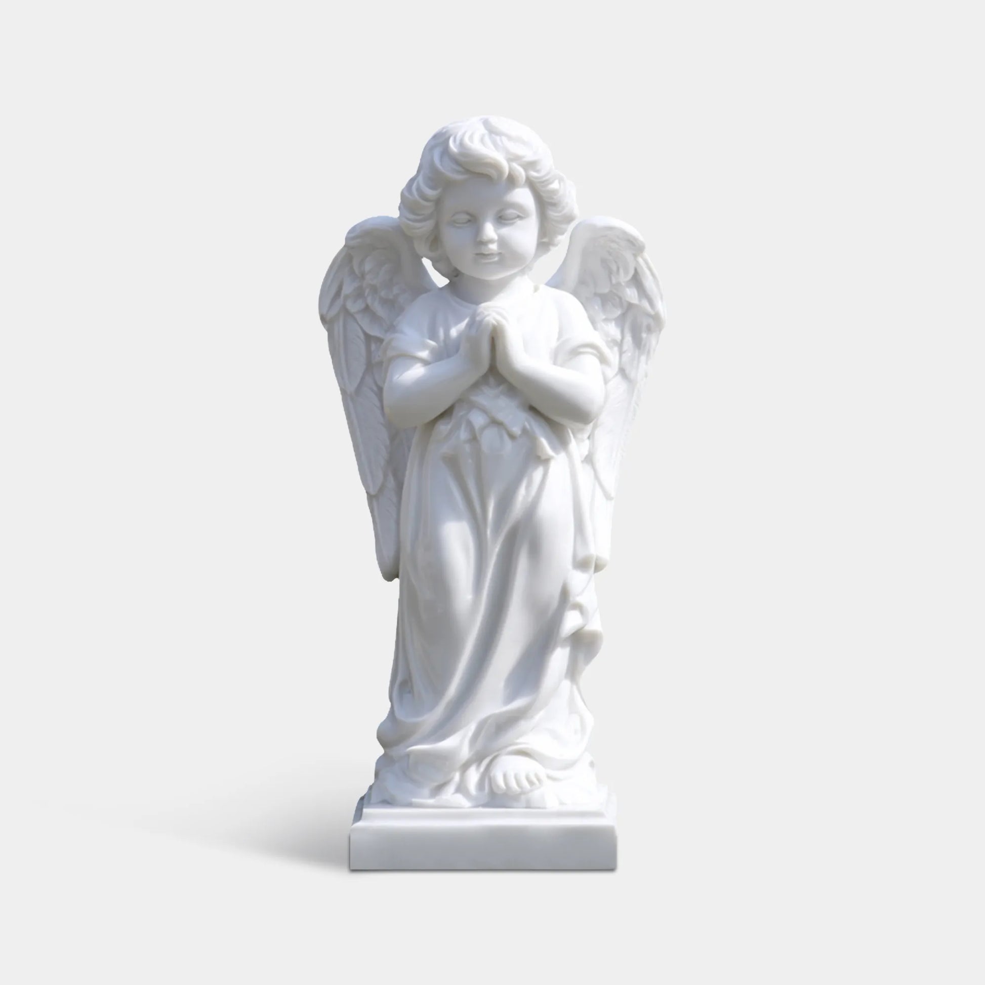 White marble angel statue in a flower shaped fountain with pink roses in a garden courtyard.