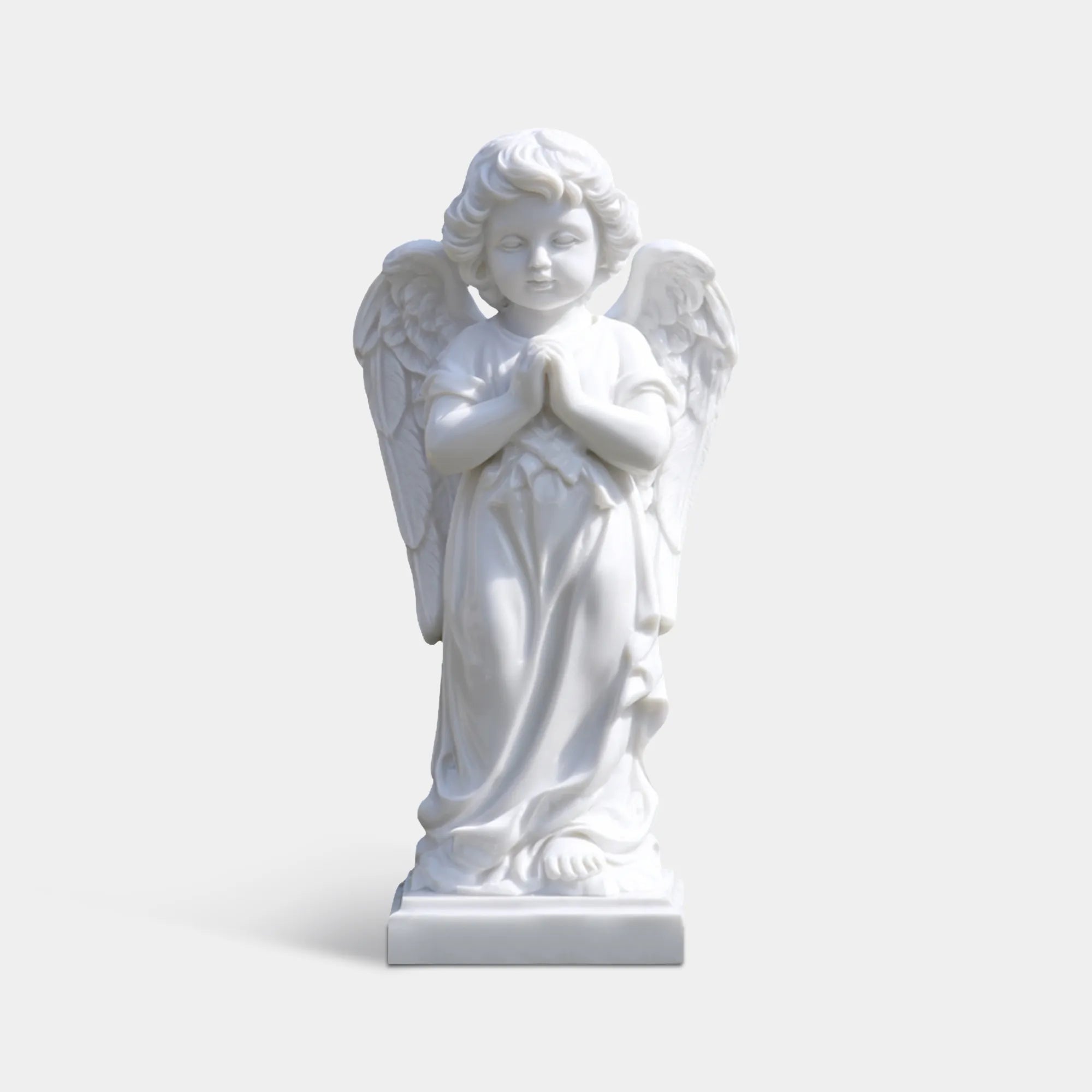 White marble angel statue in a flower shaped fountain with pink roses in a garden courtyard.